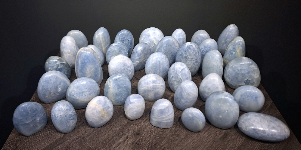 Blauwe calciet, diverse afmetingen, vanaf 11,- euro, nr. 0
Beschrijving, Calciet.

Calciet is een veelvoorkomend mineraal dat voornamelijk bestaat uit calciumcarbonaat. Het komt in diverse kleuren en vormen voor en wordt in veel industrieën gebruikt, maar ook in de esoterie. 
Algemene kenmerken:
Samenstelling: Calciet bestaat voornamelijk uit calciumcarbonaat (CaCO3). 
Vorming: Het ontstaat door afzetting van calciumcarbonaat in water, maar ook door ophoping van schelpen en skeletten van zeedieren. 
Uiterlijk: Het heeft vaak een glasachtige glans, is doorzichtig tot doorschijnend en kan vele kleuren hebben, zoals geel, oranje, rood, bruin, blauw, groen, roze, wit en kleurloos. 
Hardheid: Calciet heeft een hardheid van 3 op de schaal van Mohs. 
Veelvoorkomend: Het is een van de meest voorkomende mineralen en is een hoofdbestanddeel van kalksteen, marmer en krijt. 
Toepassingen en eigenschappen:
Industrie:
Calciet wordt gebruikt in de bouw, als grondstof voor cement, in de glasindustrie en voor de productie van optische instrumenten. 
Geologie:
Het speelt een rol bij de vorming van sedimentaire gesteenten, druipsteen en karstlandschappen. 
Esoterie:
In de edelsteentherapie wordt calciet gezien als een steen die energie versterkt, negatieve energieën verwijdert en spirituele groei bevordert. Verschillende kleuren calciet hebben specifieke eigenschappen, zoals gele calciet voor doorzettingsvermogen en moed, en mangano calciet voor emotionele heling. 
Specifieke calcietsoorten:
Gele Calciet: Staat bekend om het absorberen van negativiteit, het versterken van doorzettingsvermogen en het aantrekken van succes. 
Blauwe Calciet: Wordt geassocieerd met kalmering, communicatie en het loslaten van stress. 
Groene Calciet: Werkt op de hartchakra, bevordert liefde, compassie en emotionele heling. 
Mangano Calciet: Wordt gebruikt voor emotionele heling, het loslaten van oud verdriet en het versterken van zelfvertrouwen. 
Reiniging:
Calciet kan op verschillende manieren gereinigd worden, maar het is belangrijk om te weten dat sommige soorten, zoals gele calciet, niet goed tegen water kunnen. 
Andere reinigingsmethoden zijn bijvoorbeeld reinigen met edelstenenspray, op een Amethist of bergkristal leggen, of reinigen met selenite. 
In het kort, calciet is een veelzijdig mineraal met diverse toepassingen, zowel in de industrie als in de esoterie. Het is een steen die kan worden gebruikt voor energieversterking, emotionele heling en het bevorderen van spirituele groei, afhankelijk van de specifieke kleur en eigenschappen.