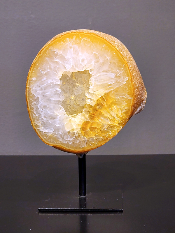 Agaat op standaard, 1 kg, 15cm hg. en 11cm br.  36,- euro, nr. 17
Agaat is een veelzijdige edelsteen die bekend staat om zijn prachtige kleurbanden en patronen. Het is een variëteit van het mineraal kwarts, meer specifiek chalcedoon, en wordt vaak gebruikt in sieraden en als decoratieve steen. 
Algemene kenmerken:
Agaat is een microkristallijne vorm van kwarts, bestaande uit microscopisch kleine kristallen. 
Kleuren en patronen:
Agaat komt voor in vele kleuren, vaak met banden of lagen in verschillende tinten. 
Agaat is een populaire keuze voor het maken van kettingen, armbanden, ringen en andere sieraden vanwege de esthetische aantrekkingskracht en duurzaamheid. 
Spirituele eigenschappen:
Agaat wordt vaak geassocieerd met aardende, stabiliserende en beschermende eigenschappen. 
Helende werking:
Er wordt aangenomen dat agaat kan helpen bij het verminderen van stress, het bevorderen van emotioneel evenwicht en het versterken van het zelfvertrouwen. 
Verzorging van agaat:
Agaat is relatief gemakkelijk te onderhouden. Het kan worden gereinigd met lauw water, de rook van witte salie of palo santo, of door het op een hematiet- of bergkristal-cluster te plaatsen. 

-	Kunstgalerie-Arnold -