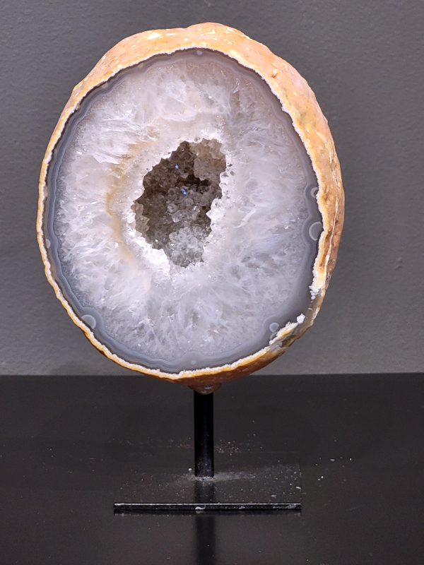 Agaat op standaard, 910 gram, 16cm hg. en 10cm br. 32,- euro, nr. 29
Agaat is een veelzijdige edelsteen die bekend staat om zijn prachtige kleurbanden en patronen. Het is een variëteit van het mineraal kwarts, meer specifiek chalcedoon, en wordt vaak gebruikt in sieraden en als decoratieve steen. 
Algemene kenmerken:
Agaat is een microkristallijne vorm van kwarts, bestaande uit microscopisch kleine kristallen. 
Kleuren en patronen:
Agaat komt voor in vele kleuren, vaak met banden of lagen in verschillende tinten. 
Agaat is een populaire keuze voor het maken van kettingen, armbanden, ringen en andere sieraden vanwege de esthetische aantrekkingskracht en duurzaamheid. 
Spirituele eigenschappen:
Agaat wordt vaak geassocieerd met aardende, stabiliserende en beschermende eigenschappen. 
Helende werking:
Er wordt aangenomen dat agaat kan helpen bij het verminderen van stress, het bevorderen van emotioneel evenwicht en het versterken van het zelfvertrouwen. 
Verzorging van agaat:
Agaat is relatief gemakkelijk te onderhouden. Het kan worden gereinigd met lauw water, de rook van witte salie of palo santo, of door het op een hematiet- of bergkristal-cluster te plaatsen. 

-	Kunstgalerie-Arnold -