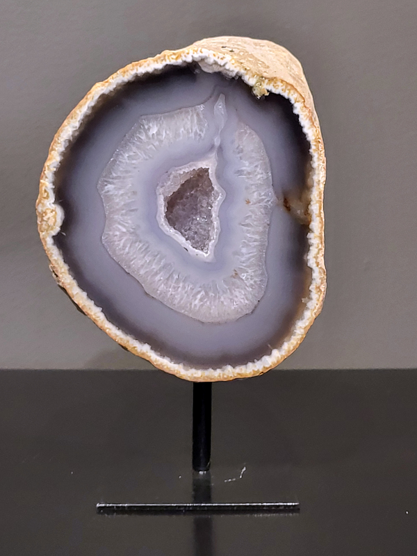 Agaat op standaard, 824 gram, 15cm hg. en 9cm br. 29,- euro, nr. 25
Agaat is een veelzijdige edelsteen die bekend staat om zijn prachtige kleurbanden en patronen. Het is een variëteit van het mineraal kwarts, meer specifiek chalcedoon, en wordt vaak gebruikt in sieraden en als decoratieve steen. 
Algemene kenmerken:
Agaat is een microkristallijne vorm van kwarts, bestaande uit microscopisch kleine kristallen. 
Kleuren en patronen:
Agaat komt voor in vele kleuren, vaak met banden of lagen in verschillende tinten. 
Agaat is een populaire keuze voor het maken van kettingen, armbanden, ringen en andere sieraden vanwege de esthetische aantrekkingskracht en duurzaamheid. 
Spirituele eigenschappen:
Agaat wordt vaak geassocieerd met aardende, stabiliserende en beschermende eigenschappen. 
Helende werking:
Er wordt aangenomen dat agaat kan helpen bij het verminderen van stress, het bevorderen van emotioneel evenwicht en het versterken van het zelfvertrouwen. 
Verzorging van agaat:
Agaat is relatief gemakkelijk te onderhouden. Het kan worden gereinigd met lauw water, de rook van witte salie of palo santo, of door het op een hematiet- of bergkristal-cluster te plaatsen. 

-	Kunstgalerie-Arnold -