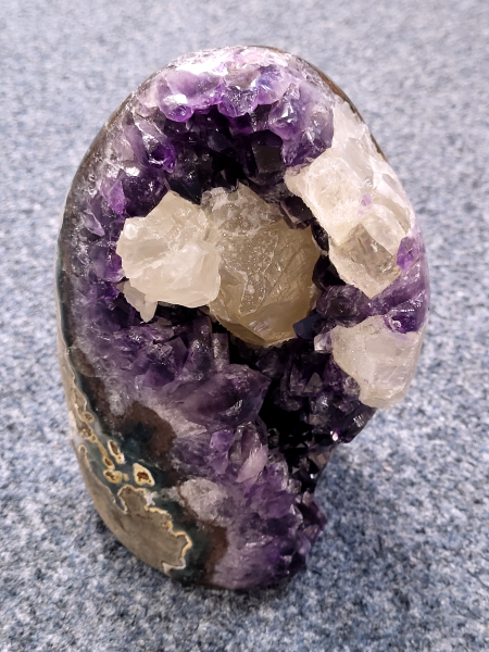 Amethist, met calciet en standvlak, 2,5 kg, 295,- euro, nr. 22

Waar komt amethist vandaan en hoe ontstaan ze?
Amethist wordt wereldwijd gevonden maar de grootste
vondsten worden gedaan in Brazilië, Uruguay, Mexico en Zambia.
Deze edelsteen komt voor in basalt holtes of geodes die ontstaan zijn door
vulkaanuitbarstingen, het duurt miljoenen jaren voordat de kristallen zich vormen.
De kleur van de amethist wordt veroorzaakt door de aanwezigheid
van ijzer en mangaan. 
Waar kan amethist niet goed tegen?
Amethist kan niet goed tegen fel zonlicht en plotselinge
temperatuurwisselingen. Langdurige blootstelling aan zonlicht
doet de kleur doen vervagen en abrupte temperatuur veranderingen
kan voor barsten en/of scheuren zorgen. Amethist kan daarentegen
wel grotendeels tegen water.
Spirituele werking van de amethist:
> Rust, spirituele groei en bescherming.
Amethist staat vooral bekend om zijn kalmerende werking.

                                                                                        -  Kunstgalerie Arnold  -