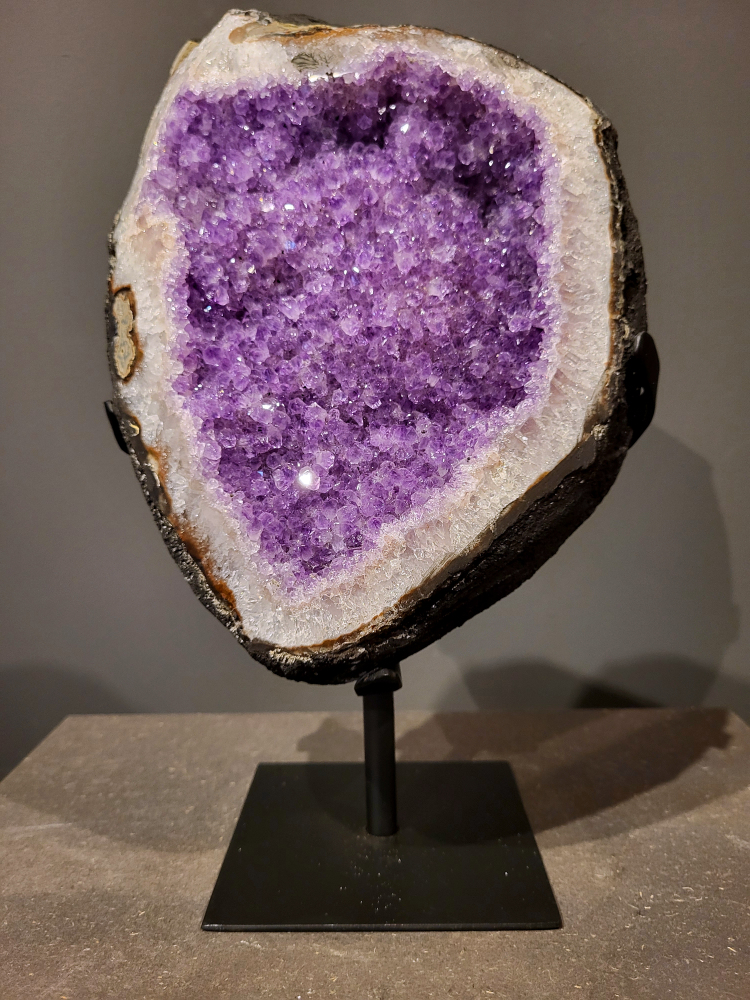 Amethist op standaard, 5,6 kg, 165,- euro, nr. 28

Waar komt amethist vandaan en hoe ontstaan ze?
Amethist wordt wereldwijd gevonden maar de grootste
vondsten worden gedaan in Brazilië, Uruguay, Mexico en Zambia.
Deze edelsteen komt voor in basalt holtes of geodes die ontstaan zijn door
vulkaanuitbarstingen, het duurt miljoenen jaren voordat de kristallen zich vormen.
De kleur van de amethist wordt veroorzaakt door de aanwezigheid
van ijzer en mangaan. 
Waar kan amethist niet goed tegen?
Amethist kan niet goed tegen fel zonlicht en plotselinge
temperatuurwisselingen. Langdurige blootstelling aan zonlicht
doet de kleur doen vervagen en abrupte temperatuur veranderingen
kan voor barsten en/of scheuren zorgen. Amethist kan daarentegen
wel grotendeels tegen water.
Spirituele werking van de amethist:
> Rust, spirituele groei en bescherming.
Amethist staat vooral bekend om zijn kalmerende werking.

                                                                                        -  Kunstgalerie Arnold  - 