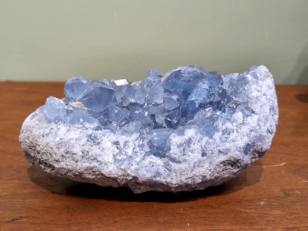 Celestien, 0,9 kg., 13cm br. 45,- euro, nr. 19
Celestien, ook wel bekend als celestiet of Coelestien, is een mineraal dat voornamelijk bestaat uit strontiumsulfaat. 
Eigenschappen en kenmerken:
Kleur: Celestien kan kleurloos, wit, grijs, blauw, groen, geel, oranje, roodachtig of bruin zijn, maar de meest voorkomende kleur is grijsblauw. 
Herkomst: Het mineraal wordt gevonden in graniet en pegmatiet, en ook gevormd bij het verdampen van zeewater. 
Spirituele betekenis en werking:
Celestien staat bekend om zijn kalmerende werking en wordt vaak gebruikt om stress, angst en nervositeit te verminderen. 
Spirituele ontwikkeling:
De steen bevordert spirituele groei, helderziendheid en telepathie. 
Fysieke werking:
Pijnstillend: Celestien kan kalmerend werken en pijn verminderen, inclusief menstruatiepijn. 
Helpt bij oog- en oorproblemen: De steen kan behulpzaam zijn bij kwalen aan ogen en oren. 
Geeft energie bij vermoeidheid: Celestien kan energie geven bij uitputting en vermoeidheid. 
Bevordert genezing: De steen zou kunnen helpen bij de genezing van botten, weefsels en organen. 
Verzorging:
Celestien is een gevoelige steen en kan beschadigen door water of zout.
                                           -  Kunstgalerie-Arnold -