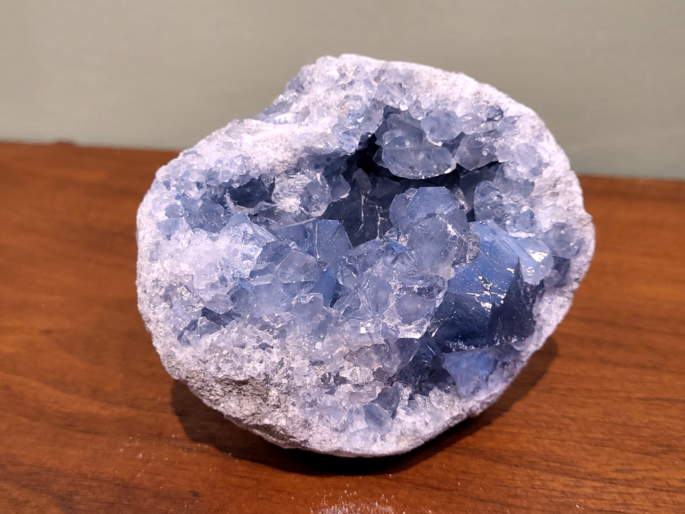 Celestien, 754 gram, 37,50 euro, nr. 5
Celestien, ook wel bekend als celestiet of Coelestien, is een mineraal dat voornamelijk bestaat uit strontiumsulfaat. 
Eigenschappen en kenmerken:
Kleur: Celestien kan kleurloos, wit, grijs, blauw, groen, geel, oranje, roodachtig of bruin zijn, maar de meest voorkomende kleur is grijsblauw. 
Herkomst: Het mineraal wordt gevonden in graniet en pegmatiet, en ook gevormd bij het verdampen van zeewater. 
Spirituele betekenis en werking:
Celestien staat bekend om zijn kalmerende werking en wordt vaak gebruikt om stress, angst en nervositeit te verminderen. 
Spirituele ontwikkeling:
De steen bevordert spirituele groei, helderziendheid en telepathie. 
Fysieke werking:
Pijnstillend: Celestien kan kalmerend werken en pijn verminderen, inclusief menstruatiepijn. 
Helpt bij oog- en oorproblemen: De steen kan behulpzaam zijn bij kwalen aan ogen en oren. 
Geeft energie bij vermoeidheid: Celestien kan energie geven bij uitputting en vermoeidheid. 
Bevordert genezing: De steen zou kunnen helpen bij de genezing van botten, weefsels en organen. 
Verzorging:
Celestien is een gevoelige steen en kan beschadigen door water of zout.
                                           -  Kunstgalerie-Arnold -