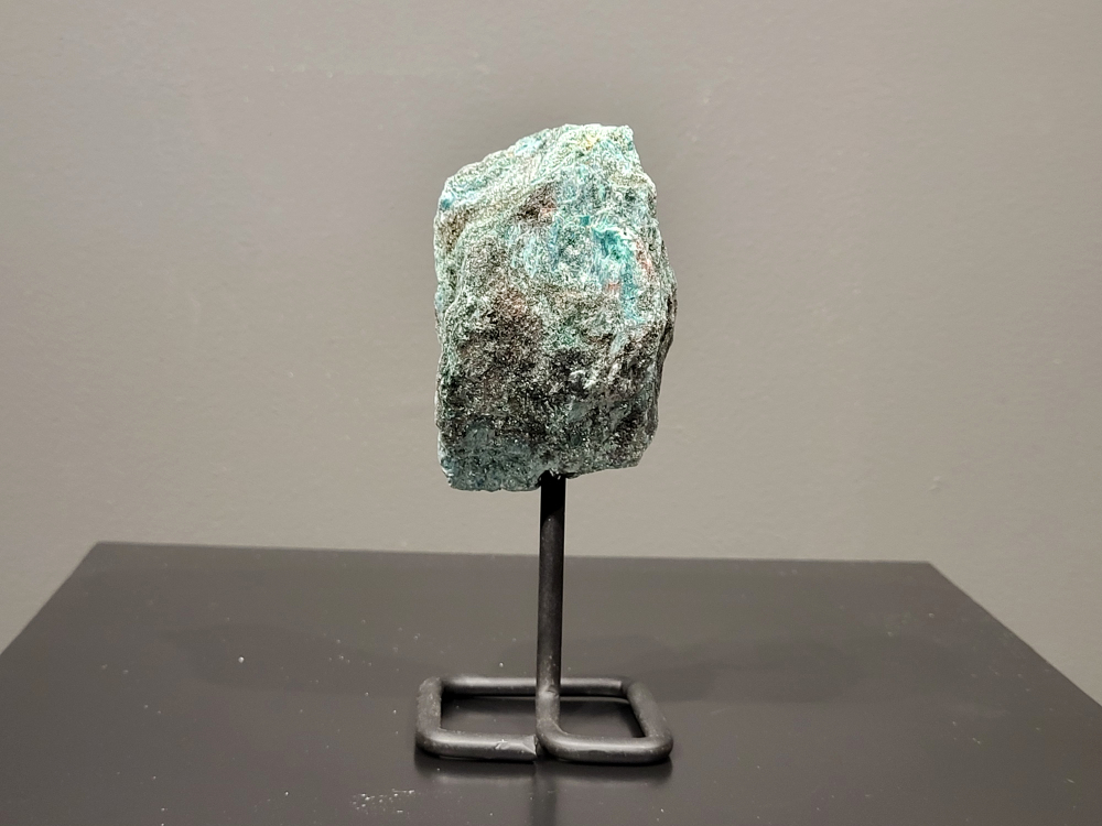 Fuchsiet op standaard, 364 gram, hoogte 15 cm, 15,- euro, nr. 17
Beschrijving, Fuchsiet.

Fuchsiet is een groene, chroomhoudende variant van muscoviet, een soort mica. Het dankt zijn kleur aan de aanwezigheid van chroom en wordt vaak gevonden in metamorf gesteente zoals gneis en schist, maar ook in stollingsgesteente zoals graniet. Fuchsiet wordt beschouwd als een steen die inzicht, zelfbeschikking en bescherming bevordert. 
Eigenschappen en werking:
Inzicht en zelfbeschikking:
Fuchsiet helpt bij het verkrijgen van inzicht in relaties en bevordert een gezonde interactie met anderen, zonder wederzijdse afhankelijkheid. 
Bescherming:
De steen beschermt tegen negatieve energieën en emoties van anderen en helpt je om je grenzen duidelijker te stellen. 
Emotionele balans:
Fuchsiet kan helpen bij het loslaten van negatieve emoties en het overwinnen van een slachtofferrol. 
Fysieke ondersteuning:
Sommige bronnen beweren dat fuchsiet ondersteunend kan werken bij allergieën, jeuk, ontstekingen, bloed- en zenuwklachten. 
Combinaties:
Fuchsiet wordt vaak gevonden met robijn, waarbij de combinatie krachtige energie, moed en doorzettingsvermogen kan versterken. 
Chakra:
Fuchsiet wordt geassocieerd met het hartchakra (4e chakra). 
Verzorging:
Fuchsiet kan beter niet met water gereinigd worden, aldus Edelstenen en Mineralen. 
Andere bronnen suggereren dat het reinigen onder stromend water of een nacht in zout water een optie is. 
Vindplaatsen:
Brazilië is een bekende vindplaats van fuchsiet.