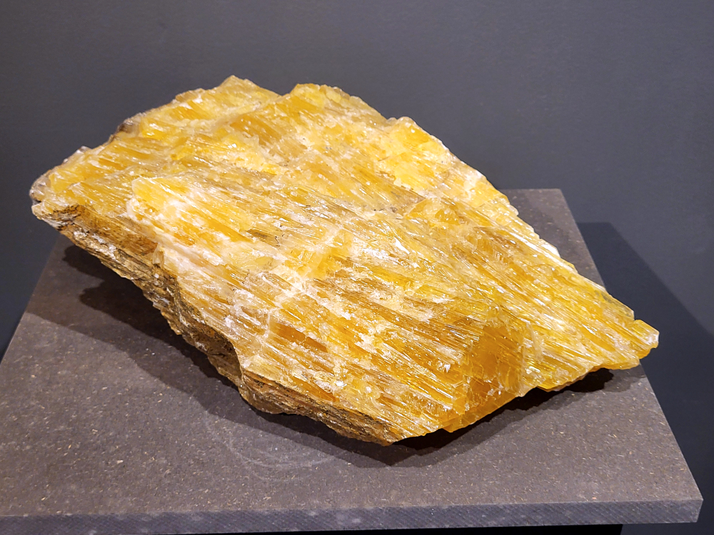 Honingcalciet, 10,4 kg, breedte 40 cm, hoogte 25cm, 185,- euro, nr. 38
Honing calciet, ook wel gele calciet genoemd, staat bekend om zijn kalmerende en stimulerende werking. Het helpt bij het loslaten van negatieve energie, bevordert innerlijke rust en moedigt aan tot actie en zelfvertrouwen. Fysiek zou honing calciet de stofwisseling en het immuunsysteem stimuleren, en een positieve invloed hebben op de botten en gewrichten. 
Stimulerend:
De steen stimuleert de geest, het denkvermogen en het geheugen. Het helpt bij het overwinnen van luiheid en geeft motivatie om doelen na te streven. 
Vergroot zelfvertrouwen:
Honing calciet kan het zelfvertrouwen vergroten en een gevoel van moed en daadkracht geven. 
Verbetert stofwisseling en immuunsysteem:
De steen stimuleert de stofwisseling en het immuunsysteem, en helpt bij de opname van calcium. 
Ondersteunt botten en gewrichten:
Honing calciet kan een positieve invloed hebben op de botten, gewrichten en het herstel van weefsels. 
Harmoniseert het hartritme:
Honing calciet kan het hartritme harmoniseren en heeft een positieve invloed op het hart. 
Spiritueel:
Reinigend:
Honing calciet kan negatieve energie uit ruimtes absorberen en de aura zuiveren.
Brengt harmonie tussen hart en hoofd:
De warme, zachte energie van de steen brengt harmonie tussen hart en hoofd. 
Let op: Honing calciet is een zachte steen en kan breken. Het is belangrijk om de steen niet te veel bloot te stellen aan water. 
                                        - Kunstgalerie-Arnold -