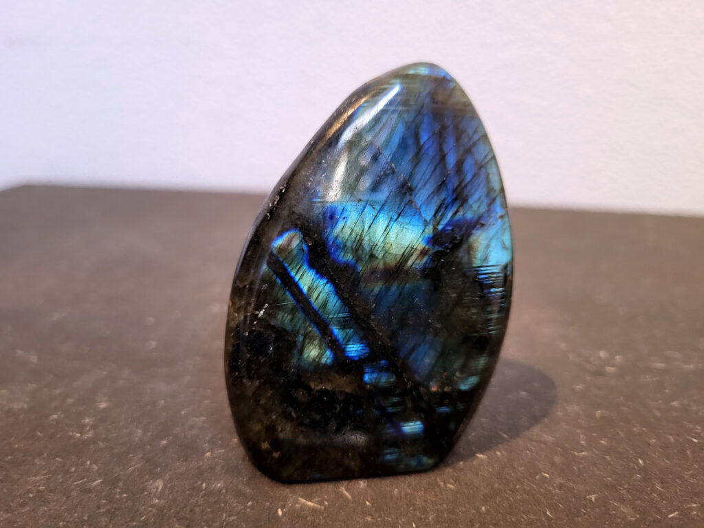 Labradoriet, 0,2kg, 7cm hoog, 8,- euro, nr. 40
Beschrijving, Labradoriet.
Labradoriet is een edelsteen die bekend staat om zijn iriserende kleurenspel, ook wel labradoriseren genoemd, dat vaak doet denken aan het noorderlicht. Het is een populaire steen in de edelstenenwereld vanwege zowel zijn uiterlijk als zijn vermeende spirituele eigenschappen. 
Wat is labradoriet?
Labradoriet is een veldspaatmineraal dat wordt gekenmerkt door een opaalachtig glans of iriserend effect, veroorzaakt door de lichtbreking in de interne structuur van de steen.
De meest voorkomende kleur is grijs of groenachtig grijs, maar de steen kan ook blauwe, gele, oranje, paarse of zelfs rode flitsen laten zien.
De steen is genoemd naar het Canadese schiereiland Labrador, waar het voor het eerst werd ontdekt. 
Spirituele betekenis en eigenschappen:
Labradoriet wordt vaak beschouwd als een beschermende steen, vooral voor mensen die gevoelig zijn voor de energieën van hun omgeving. 
Het zou helpen bij het versterken van de aura en het verminderen van energielekkage, waardoor je je weerbaarder voelt. 
Labradoriet wordt geassocieerd met het versterken van intuïtie, het vergroten van het bewustzijn en het transformeren van negatieve energieën. 
Het wordt ook gebruikt om blokkades op te heffen en de innerlijke wijsheid te onthullen. 
Gebruik:
Labradoriet wordt vaak verwerkt in sieraden zoals hangers, armbanden en oorbellen. 
Het kan ook als ruwe steen, knuffelsteen of in andere vormen worden gebruikt, bijvoorbeeld in een huis of op een werkplek. 
Labradoriet kan worden gereinigd door het onder stromend water te houden of door het te reinigen met een andere steen zoals bergkristal of seleniet. 
Vindplaatsen:
Labradoriet wordt gevonden op verschillende locaties over de hele wereld, waaronder Canada, Finland, Madagaskar en Rusland. 
                                -Kunstgalerie Arnold-
