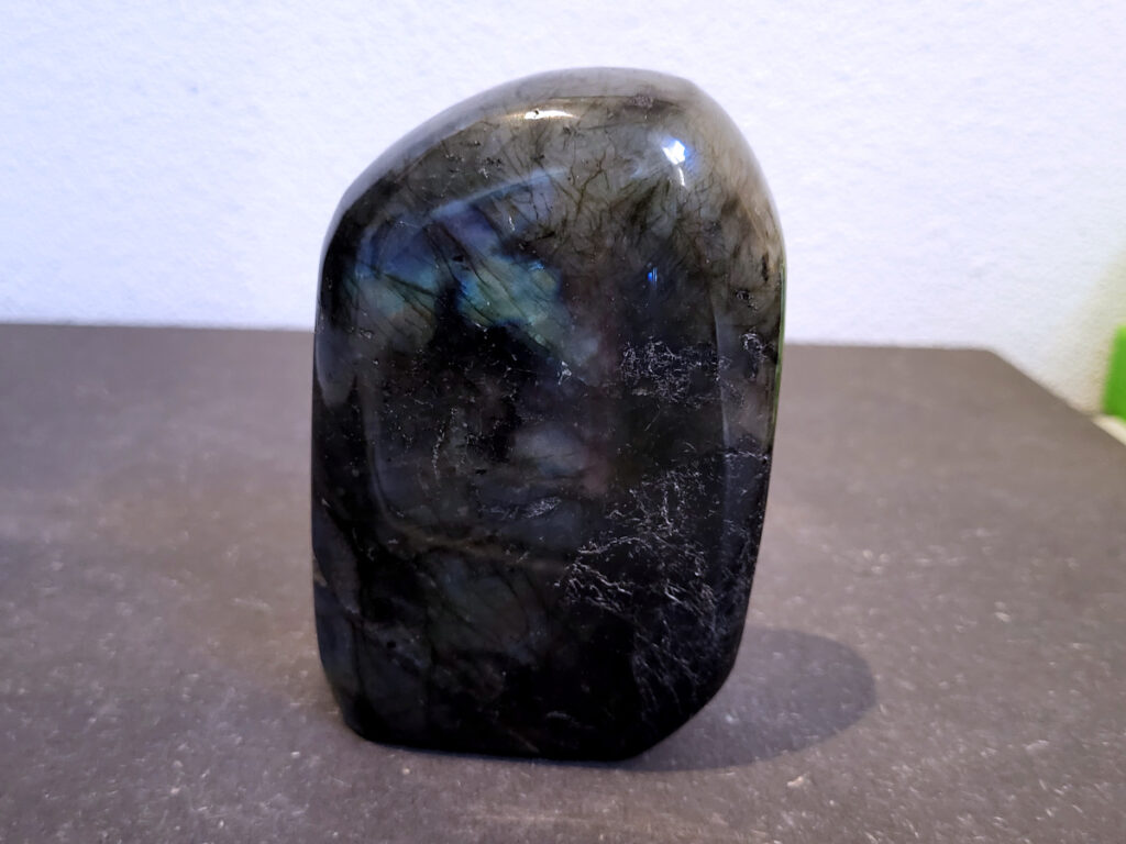 Labradoriet, 0,6kg, 11cm hoog, 18,-euro, nr. 38
Beschrijving, Labradoriet.
Labradoriet is een edelsteen die bekend staat om zijn iriserende kleurenspel, ook wel labradoriseren genoemd, dat vaak doet denken aan het noorderlicht. Het is een populaire steen in de edelstenenwereld vanwege zowel zijn uiterlijk als zijn vermeende spirituele eigenschappen. 
Wat is labradoriet?
Labradoriet is een veldspaatmineraal dat wordt gekenmerkt door een opaalachtig glans of iriserend effect, veroorzaakt door de lichtbreking in de interne structuur van de steen.
De meest voorkomende kleur is grijs of groenachtig grijs, maar de steen kan ook blauwe, gele, oranje, paarse of zelfs rode flitsen laten zien.
De steen is genoemd naar het Canadese schiereiland Labrador, waar het voor het eerst werd ontdekt. 
Spirituele betekenis en eigenschappen:
Labradoriet wordt vaak beschouwd als een beschermende steen, vooral voor mensen die gevoelig zijn voor de energieën van hun omgeving. 
Het zou helpen bij het versterken van de aura en het verminderen van energielekkage, waardoor je je weerbaarder voelt. 
Labradoriet wordt geassocieerd met het versterken van intuïtie, het vergroten van het bewustzijn en het transformeren van negatieve energieën. 
Het wordt ook gebruikt om blokkades op te heffen en de innerlijke wijsheid te onthullen. 
Gebruik:
Labradoriet wordt vaak verwerkt in sieraden zoals hangers, armbanden en oorbellen. 
Het kan ook als ruwe steen, knuffelsteen of in andere vormen worden gebruikt, bijvoorbeeld in een huis of op een werkplek. 
Labradoriet kan worden gereinigd door het onder stromend water te houden of door het te reinigen met een andere steen zoals bergkristal of seleniet. 
Vindplaatsen:
Labradoriet wordt gevonden op verschillende locaties over de hele wereld, waaronder Canada, Finland, Madagaskar en Rusland. 
                                -Kunstgalerie Arnold-