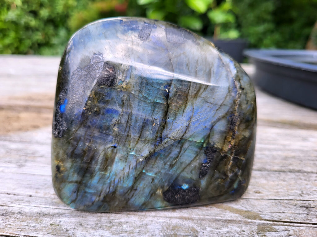 Labradoriet, 540 gram, 16,- euro, nr. 11, Labradoriet is een edelsteen die bekend staat om zijn iriserende kleurenspel, ook wel labradorisatie genoemd, dat vaak blauwe, groene, gouden of paarse tinten omvat. Deze steen wordt beschouwd als een krachtige beschermer en transformatie-steen, die helpt om verborgen krachten en gaven naar boven te halen. Kenmerken en eigenschappen: Veldspaat: Labradoriet is een veldspaatmineraal, specifiek een calcium-natrium-aluminium-tectosilicaat met de chemische formule (Ca,Na)(Si,Al)4O8. Labradorisatie: Het opvallende kleurenspel is te danken aan lichtbreking binnen de steen, veroorzaakt door microscopische lamellen van verschillende samenstelling. Bescherming: Labradoriet wordt vaak gebruikt als beschermsteen, vooral door hoogsensitieve mensen, omdat het de aura versterkt en beschermt tegen negatieve energieën. Spirituele werking: Het wordt geassocieerd met het verhogen van bewustzijn, het aarden van spirituele energieën, en het versterken van intuïtie. Vindplaatsen: Labradoriet wordt gevonden op verschillende plekken wereldwijd, waaronder Labrador (Canada), Finland, Madagaskar, en India. Spirituele en energetische werking: Bescherming: Labradoriet beschermt de aura en helpt om energieverlies te voorkomen, vooral in drukke omgevingen. Intuïtie: De steen wordt in verband gebracht met het versterken van intuïtie en het vergroten van het spirituele bewustzijn.