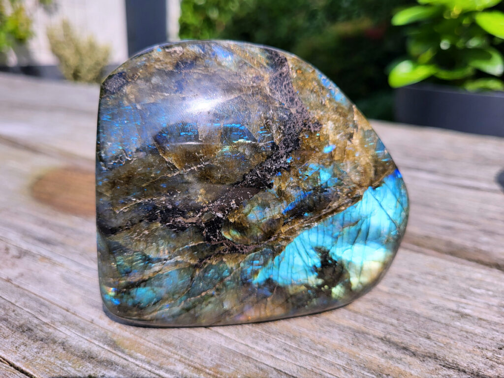 Labradoriet, 610 gram, 18,- euro, nr. 12, Labradoriet is een edelsteen die bekend staat om zijn iriserende kleurenspel, ook wel labradorisatie genoemd, dat vaak blauwe, groene, gouden of paarse tinten omvat. Deze steen wordt beschouwd als een krachtige beschermer en transformatie-steen, die helpt om verborgen krachten en gaven naar boven te halen. Kenmerken en eigenschappen: Veldspaat: Labradoriet is een veldspaatmineraal, specifiek een calcium-natrium-aluminium-tectosilicaat met de chemische formule (Ca,Na)(Si,Al)4O8. Labradorisatie: Het opvallende kleurenspel is te danken aan lichtbreking binnen de steen, veroorzaakt door microscopische lamellen van verschillende samenstelling. Bescherming: Labradoriet wordt vaak gebruikt als beschermsteen, vooral door hoogsensitieve mensen, omdat het de aura versterkt en beschermt tegen negatieve energieën. Spirituele werking: Het wordt geassocieerd met het verhogen van bewustzijn, het aarden van spirituele energieën, en het versterken van intuïtie. Vindplaatsen: Labradoriet wordt gevonden op verschillende plekken wereldwijd, waaronder Labrador (Canada), Finland, Madagaskar, en India. Spirituele en energetische werking: Bescherming: Labradoriet beschermt de aura en helpt om energieverlies te voorkomen, vooral in drukke omgevingen. Intuïtie: De steen wordt in verband gebracht met het versterken van intuïtie en het vergroten van het spirituele bewustzijn.