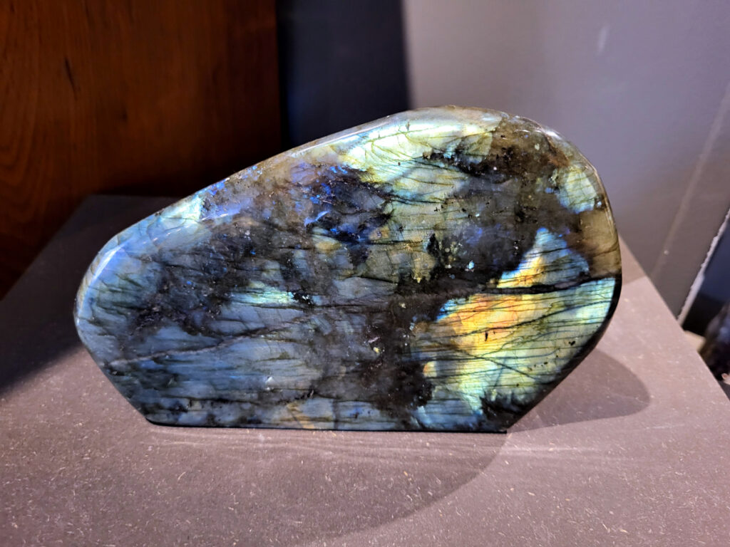 Labradoriet 3,3kg, 22cm breed, 114-euro, nr. 2
Beschrijving, Labradoriet.
Labradoriet is een edelsteen die bekend staat om zijn iriserende kleurenspel, ook wel labradoriseren genoemd, dat vaak doet denken aan het noorderlicht. Het is een populaire steen in de edelstenenwereld vanwege zowel zijn uiterlijk als zijn vermeende spirituele eigenschappen. 
Wat is labradoriet?
Labradoriet is een veldspaatmineraal dat wordt gekenmerkt door een opaalachtig glans of iriserend effect, veroorzaakt door de lichtbreking in de interne structuur van de steen.
De meest voorkomende kleur is grijs of groenachtig grijs, maar de steen kan ook blauwe, gele, oranje, paarse of zelfs rode flitsen laten zien.
De steen is genoemd naar het Canadese schiereiland Labrador, waar het voor het eerst werd ontdekt. 
Spirituele betekenis en eigenschappen:
Labradoriet wordt vaak beschouwd als een beschermende steen, vooral voor mensen die gevoelig zijn voor de energieën van hun omgeving. 
Het zou helpen bij het versterken van de aura en het verminderen van energielekkage, waardoor je je weerbaarder voelt. 
Labradoriet wordt geassocieerd met het versterken van intuïtie, het vergroten van het bewustzijn en het transformeren van negatieve energieën. 
Het wordt ook gebruikt om blokkades op te heffen en de innerlijke wijsheid te onthullen. 
Gebruik:
Labradoriet wordt vaak verwerkt in sieraden zoals hangers, armbanden en oorbellen. 
Het kan ook als ruwe steen, knuffelsteen of in andere vormen worden gebruikt, bijvoorbeeld in een huis of op een werkplek. 
Labradoriet kan worden gereinigd door het onder stromend water te houden of door het te reinigen met een andere steen zoals bergkristal of seleniet. 
Vindplaatsen:
Labradoriet wordt gevonden op verschillende locaties over de hele wereld, waaronder Canada, Finland, Madagaskar en Rusland. 

                 -kunstgalerie-arnold-