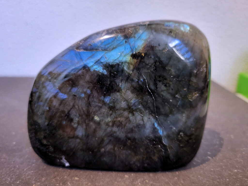 Labradoriet, 0,7kg, 10cm breed, 20,-euro, nr. 27
Beschrijving, Labradoriet.
Labradoriet is een edelsteen die bekend staat om zijn iriserende kleurenspel, ook wel labradoriseren genoemd, dat vaak doet denken aan het noorderlicht. Het is een populaire steen in de edelstenenwereld vanwege zowel zijn uiterlijk als zijn vermeende spirituele eigenschappen. 
Wat is labradoriet?
Labradoriet is een veldspaatmineraal dat wordt gekenmerkt door een opaalachtig glans of iriserend effect, veroorzaakt door de lichtbreking in de interne structuur van de steen.
De meest voorkomende kleur is grijs of groenachtig grijs, maar de steen kan ook blauwe, gele, oranje, paarse of zelfs rode flitsen laten zien.
De steen is genoemd naar het Canadese schiereiland Labrador, waar het voor het eerst werd ontdekt. 
Spirituele betekenis en eigenschappen:
Labradoriet wordt vaak beschouwd als een beschermende steen, vooral voor mensen die gevoelig zijn voor de energieën van hun omgeving. 
Het zou helpen bij het versterken van de aura en het verminderen van energielekkage, waardoor je je weerbaarder voelt. 
Labradoriet wordt geassocieerd met het versterken van intuïtie, het vergroten van het bewustzijn en het transformeren van negatieve energieën. 
Het wordt ook gebruikt om blokkades op te heffen en de innerlijke wijsheid te onthullen. 
Gebruik:
Labradoriet wordt vaak verwerkt in sieraden zoals hangers, armbanden en oorbellen. 
Het kan ook als ruwe steen, knuffelsteen of in andere vormen worden gebruikt, bijvoorbeeld in een huis of op een werkplek. 
Labradoriet kan worden gereinigd door het onder stromend water te houden of door het te reinigen met een andere steen zoals bergkristal of seleniet. 
Vindplaatsen:
Labradoriet wordt gevonden op verschillende locaties over de hele wereld, waaronder Canada, Finland, Madagaskar en Rusland. 
                                -Kunstgalerie Arnold-