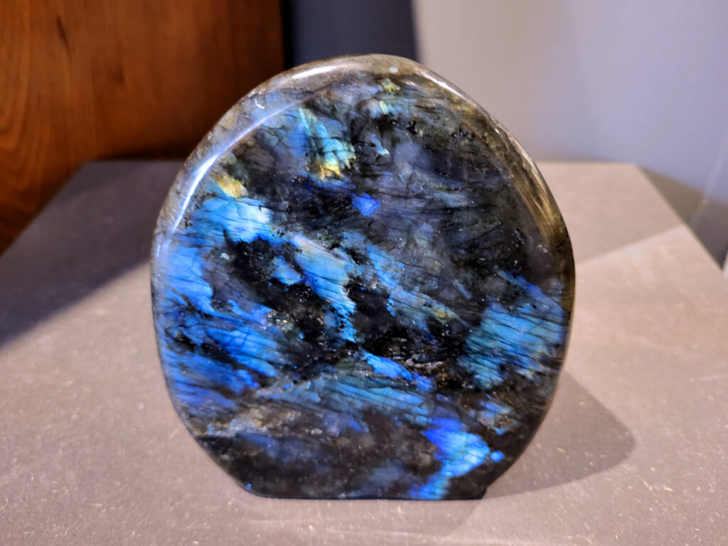 Labradoriet, 1,6kg, 14cm hoog, 55,- euro, nr. 8
Beschrijving, Labradoriet.
Labradoriet is een edelsteen die bekend staat om zijn iriserende kleurenspel, ook wel labradoriseren genoemd, dat vaak doet denken aan het noorderlicht. Het is een populaire steen in de edelstenenwereld vanwege zowel zijn uiterlijk als zijn vermeende spirituele eigenschappen. 
Wat is labradoriet?
Labradoriet is een veldspaatmineraal dat wordt gekenmerkt door een opaalachtig glans of iriserend effect, veroorzaakt door de lichtbreking in de interne structuur van de steen.
De meest voorkomende kleur is grijs of groenachtig grijs, maar de steen kan ook blauwe, gele, oranje, paarse of zelfs rode flitsen laten zien.
De steen is genoemd naar het Canadese schiereiland Labrador, waar het voor het eerst werd ontdekt. 
Spirituele betekenis en eigenschappen:
Labradoriet wordt vaak beschouwd als een beschermende steen, vooral voor mensen die gevoelig zijn voor de energieën van hun omgeving. 
Het zou helpen bij het versterken van de aura en het verminderen van energielekkage, waardoor je je weerbaarder voelt. 
Labradoriet wordt geassocieerd met het versterken van intuïtie, het vergroten van het bewustzijn en het transformeren van negatieve energieën. 
Het wordt ook gebruikt om blokkades op te heffen en de innerlijke wijsheid te onthullen. 
Gebruik:
Labradoriet wordt vaak verwerkt in sieraden zoals hangers, armbanden en oorbellen. 
Het kan ook als ruwe steen, knuffelsteen of in andere vormen worden gebruikt, bijvoorbeeld in een huis of op een werkplek. 
Labradoriet kan worden gereinigd door het onder stromend water te houden of door het te reinigen met een andere steen zoals bergkristal of seleniet. 
Vindplaatsen:
Labradoriet wordt gevonden op verschillende locaties over de hele wereld, waaronder Canada, Finland, Madagaskar en Rusland. 

                                -kunstgalerie arnold-