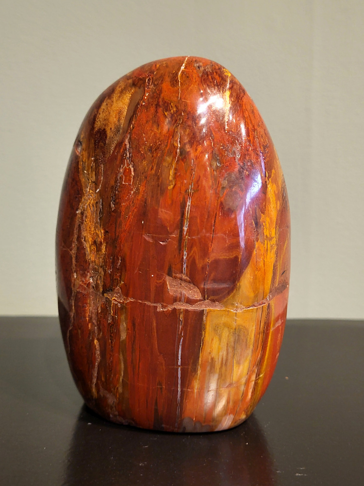 Versteend hout, 0,9kg, 12cm hoog, 28,- euro, nr. 82
Versteend hout is miljoenen jaren oud!
Chakra: wortelchakra (Muladhara)
Waar komt versteend hout vandaan en hoe ontstaan het?
Versteend hout, of gefossiliseerd hout, ontstaat wanneer een boom na zijn overlijden bedekt wordt door sediment, waardoor het langzaam omgezet wordt in steen. In plaats van te vergaan, wordt het hout geleidelijk vervangen door mineralen zoals silica. Dit proces behoudt de originele structuur van het hout, inclusief details zoals jaarringen en nerven. Het kan miljoenen jaren duren, aangezien het water dat rijk is aan mineralen de houtcellen binnendringt, terwijl zuurstof geen rol meer speelt in de afbraak.
De kleur van versteend hout is precies zoals het hout er oorspronkelijk uit zag.
Spirituele werking van versteend hout:
> stabiliteit, rust en veiligheid
Fysiek zou het positieve effecten hebben op het skelet, de botten en de rug, en kan het ondersteuning bieden bij aandoeningen zoals osteoporose en ADHD.
- Kunstgalerie Arnold -