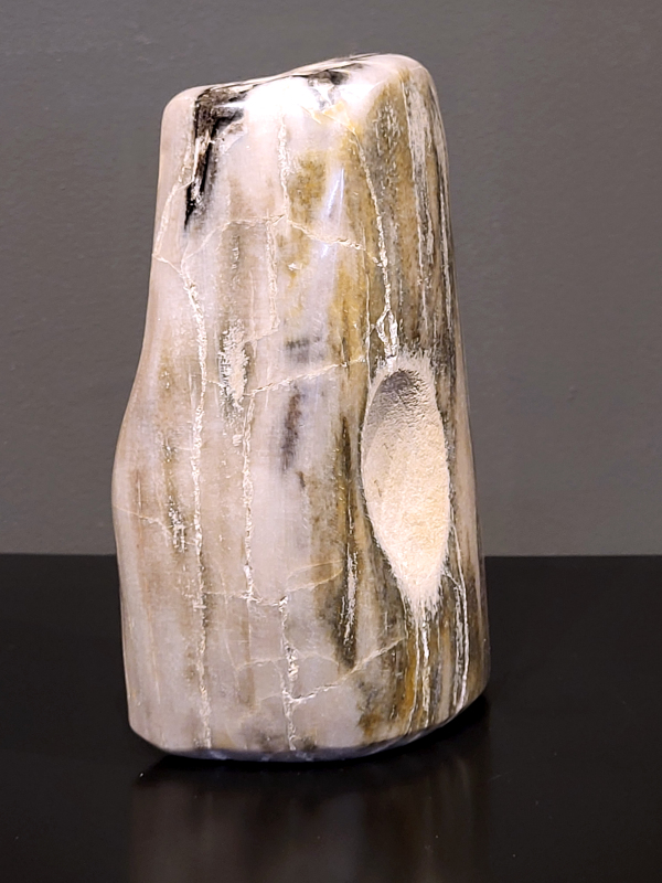 Versteend hout, 1,5 kg, 19cm hg. en 12cm br. 30,- euro, nr. 68
Versteend hout is miljoenen jaren oud!
Chakra: wortelchakra (Muladhara)
Waar komt versteend hout vandaan en hoe ontstaan het?
Versteend hout, of gefossiliseerd hout, ontstaat wanneer een boom na zijn overlijden bedekt wordt door sediment, waardoor het langzaam omgezet wordt in steen. In plaats van te vergaan, wordt het hout geleidelijk vervangen door mineralen zoals silica. Dit proces behoudt de originele structuur van het hout, inclusief details zoals jaarringen en nerven. Het kan miljoenen jaren duren, aangezien het water dat rijk is aan mineralen de houtcellen binnendringt, terwijl zuurstof geen rol meer speelt in de afbraak.
De kleur van versteend hout is precies zoals het hout er oorspronkelijk uit zag.
Spirituele werking van versteend hout: 
> stabiliteit, rust en veiligheid
Fysiek zou het positieve effecten hebben op het skelet, de botten en de rug, en kan het ondersteuning bieden bij aandoeningen zoals osteoporose en ADHD.
                                                                                        -   Kunstgalerie Arnold   -