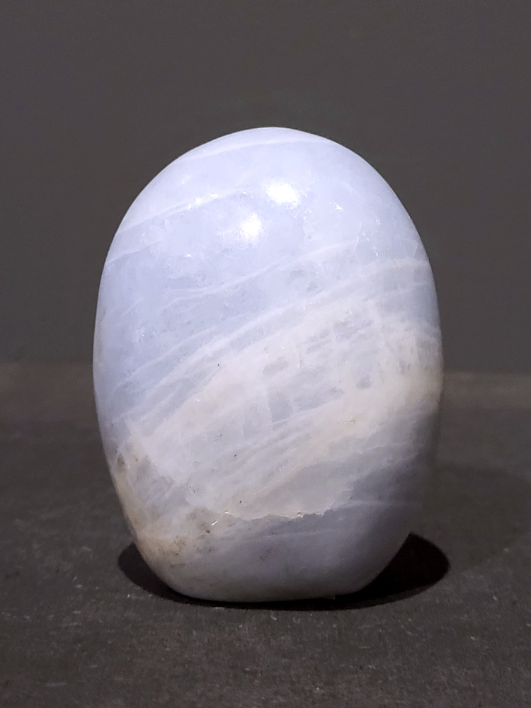 Blauwe calciet, 0,4kg, 8cm hoog, 13,- euro, nr. 13
Calciet is een veelvoorkomend mineraal dat voornamelijk bestaat uit calciumcarbonaat. Het komt in diverse kleuren en vormen voor en wordt in veel industrieën gebruikt, maar ook in de esoterie. 
Algemene kenmerken:
Samenstelling: Calciet bestaat voornamelijk uit calciumcarbonaat (CaCO3). 
Vorming: Het ontstaat door afzetting van calciumcarbonaat in water, maar ook door ophoping van schelpen en skeletten van zeedieren. 
Uiterlijk: Het heeft vaak een glasachtige glans, is doorzichtig tot doorschijnend en kan vele kleuren hebben, zoals geel, oranje, rood, bruin, blauw, groen, roze, wit en kleurloos. 
Hardheid: Calciet heeft een hardheid van 3 op de schaal van Mohs. 
Veelvoorkomend: Het is een van de meest voorkomende mineralen en is een hoofdbestanddeel van kalksteen, marmer en krijt. 
Esoterie:
In de edelsteentherapie wordt calciet gezien als een steen die energie versterkt, negatieve energieën verwijdert en spirituele groei bevordert. Verschillende kleuren calciet hebben specifieke eigenschappen, zoals gele calciet voor doorzettingsvermogen en moed, en mangano calciet voor emotionele heling. 
Specifieke calcietsoorten:
Gele Calciet: Staat bekend om het absorberen van negativiteit, het versterken van doorzettingsvermogen en het aantrekken van succes. 
Blauwe Calciet: Wordt geassocieerd met kalmering, communicatie en het loslaten van stress. 
Groene Calciet: Werkt op de hartchakra, bevordert liefde, compassie en emotionele heling. 
Mangano Calciet: Wordt gebruikt voor emotionele heling, het loslaten van oud verdriet en het versterken van zelfvertrouwen. 
Reiniging:
Calciet kan op verschillende manieren gereinigd worden, maar het is belangrijk om te weten dat sommige soorten, zoals gele calciet, niet goed tegen water kunnen. 
Andere reinigingsmethoden zijn bijvoorbeeld reinigen met edelstenenspray, op een Amethist of bergkristal leggen, of reinigen met selenite. 
Het is een steen die kan worden gebruikt voor energieversterking, emotionele heling en het bevorderen van spirituele groei, afhankelijk van de specifieke kleur en eigenschappen.