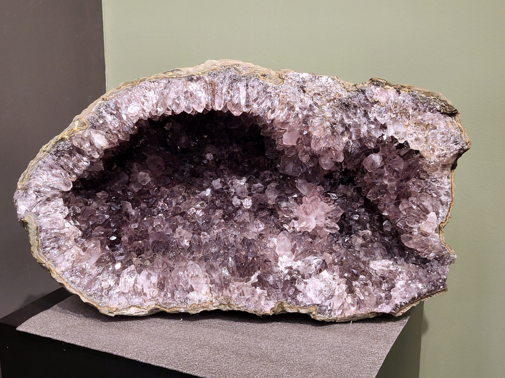 Amethist, 38kg, 55cm doorsnee en33cm hoog, 850,- euro, nr. 9b
Waar komt amethist vandaan en hoe ontstaan ze?
Amethist wordt wereldwijd gevonden maar de grootste
vondsten worden gedaan in Brazilië, Uruguay, Mexico en Zambia.
Deze edelsteen komt voor in basalt holtes of geodes die ontstaan zijn door
vulkaanuitbarstingen, het duurt miljoenen jaren voordat de kristallen zich vormen.
De kleur van de amethist wordt veroorzaakt door de aanwezigheid
van ijzer en mangaan.
Waar kan amethist niet goed tegen?
Amethist kan niet goed tegen fel zonlicht en plotselinge
temperatuurwisselingen. Langdurige blootstelling aan zonlicht
doet de kleur doen vervagen en abrupte temperatuur veranderingen
kan voor barsten en/of scheuren zorgen. Amethist kan daarentegen
wel grotendeels tegen water.
Spirituele werking van de amethist:
> Rust, spirituele groei en bescherming.
Amethist staat vooral bekend om zijn kalmerende werking.

- Kunstgalerie Arnold -