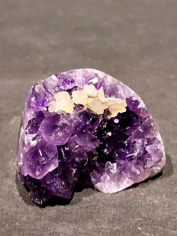 Amethist druzy, 0,1 kg, 4,- euro, nr. 1

Beschrijving Amethist.
Amethist is een paarse variëteit van kwarts, bekend om zijn kalmerende en spirituele eigenschappen. De kleur varieert van licht lila tot diep violet en wordt veroorzaakt door sporen van ijzer en andere elementen. Amethist wordt al eeuwenlang gewaardeerd, zowel vanwege zijn esthetische schoonheid als zijn vermeende genezende en beschermende krachten. 
Amethist is een kwartskristal, vaak te vinden in geodes (holtes in gesteente) of als afzonderlijke kristallen. 
De kleur varieert van lichtpaars tot diep violet, soms met roze of blauwe tinten. 
De kleurintensiteit kan variëren, waarbij donkerdere amethisten vaak als kwalitatief worden beschouwd. 
Soms vertoont amethist dichroïsme, waarbij je verschillende kleuren kunt zien wanneer je de steen in het licht draait. 

Vindplaatsen:
Amethist wordt gevonden in verschillende delen van de wereld, waaronder Brazilië, Uruguay, Zambia, Madagaskar, Rusland en Canada.
Het wordt vaak gevonden in bergachtige gebieden. 

Gebruik:
Amethist wordt gebruikt in sieraden, decoratieve objecten en als helende steen. 
Het wordt vaak gedragen als hanger, ring of armband, of geplaatst in ruimtes om de energie te zuiveren. 
Amethist wordt ook gebruikt in meditatie en andere spirituele praktijken. 