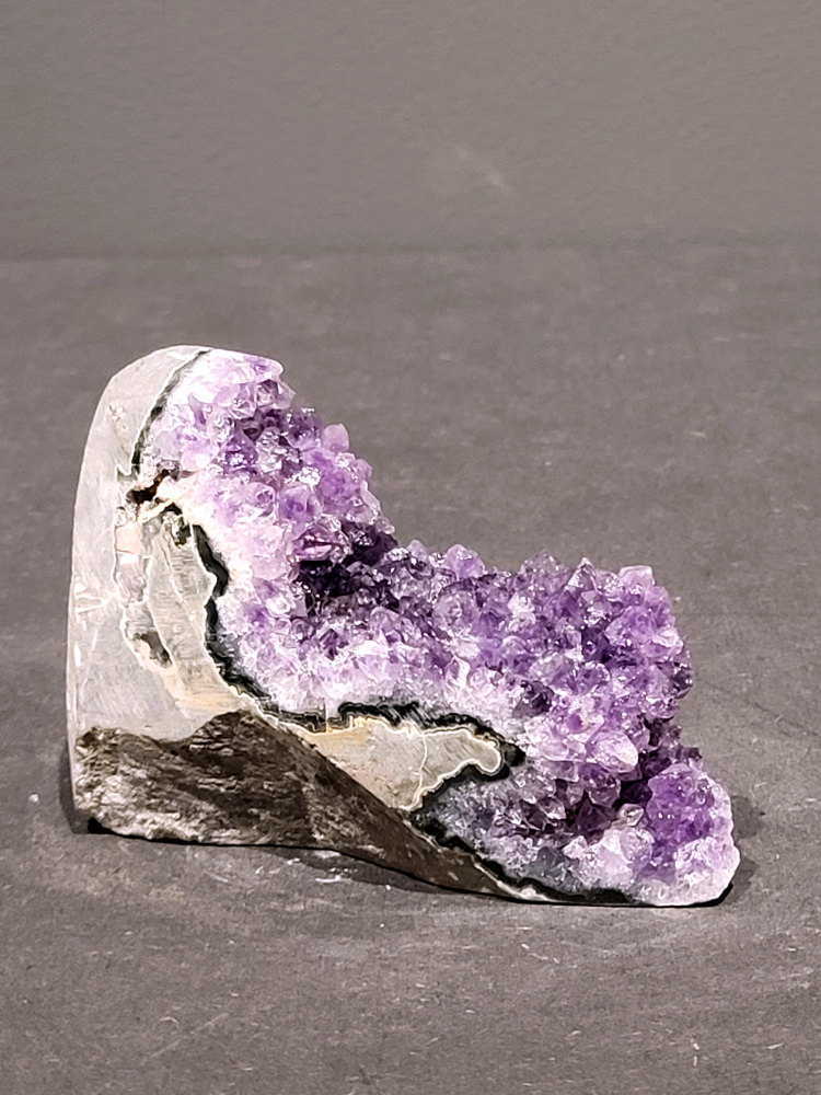 Amethist druzy, 0,2kg, 9,- euro, nr.6

Beschrijving Amethist.
Amethist is een paarse variëteit van kwarts, bekend om zijn kalmerende en spirituele eigenschappen. De kleur varieert van licht lila tot diep violet en wordt veroorzaakt door sporen van ijzer en andere elementen. Amethist wordt al eeuwenlang gewaardeerd, zowel vanwege zijn esthetische schoonheid als zijn vermeende genezende en beschermende krachten. 
Amethist is een kwartskristal, vaak te vinden in geodes (holtes in gesteente) of als afzonderlijke kristallen. 
De kleur varieert van lichtpaars tot diep violet, soms met roze of blauwe tinten. 
De kleurintensiteit kan variëren, waarbij donkerdere amethisten vaak als kwalitatief worden beschouwd. 
Soms vertoont amethist dichroïsme, waarbij je verschillende kleuren kunt zien wanneer je de steen in het licht draait. 

Vindplaatsen:
Amethist wordt gevonden in verschillende delen van de wereld, waaronder Brazilië, Uruguay, Zambia, Madagaskar, Rusland en Canada.
Het wordt vaak gevonden in bergachtige gebieden. 

Gebruik:
Amethist wordt gebruikt in sieraden, decoratieve objecten en als helende steen. 
Het wordt vaak gedragen als hanger, ring of armband, of geplaatst in ruimtes om de energie te zuiveren. 
Amethist wordt ook gebruikt in meditatie en andere spirituele praktijken. 