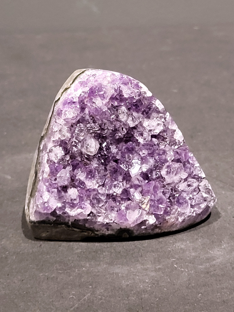Amethist druzy, 0,3kg, 12,- euro, nr.22

Beschrijving Amethist.
Amethist is een paarse variëteit van kwarts, bekend om zijn kalmerende en spirituele eigenschappen. De kleur varieert van licht lila tot diep violet en wordt veroorzaakt door sporen van ijzer en andere elementen. Amethist wordt al eeuwenlang gewaardeerd, zowel vanwege zijn esthetische schoonheid als zijn vermeende genezende en beschermende krachten. 
Amethist is een kwartskristal, vaak te vinden in geodes (holtes in gesteente) of als afzonderlijke kristallen. 
De kleur varieert van lichtpaars tot diep violet, soms met roze of blauwe tinten. 
De kleurintensiteit kan variëren, waarbij donkerdere amethisten vaak als kwalitatief worden beschouwd. 
Soms vertoont amethist dichroïsme, waarbij je verschillende kleuren kunt zien wanneer je de steen in het licht draait. 

Vindplaatsen:
Amethist wordt gevonden in verschillende delen van de wereld, waaronder Brazilië, Uruguay, Zambia, Madagaskar, Rusland en Canada.
Het wordt vaak gevonden in bergachtige gebieden. 

Gebruik:
Amethist wordt gebruikt in sieraden, decoratieve objecten en als helende steen. 
Het wordt vaak gedragen als hanger, ring of armband, of geplaatst in ruimtes om de energie te zuiveren. 
Amethist wordt ook gebruikt in meditatie en andere spirituele praktijken.