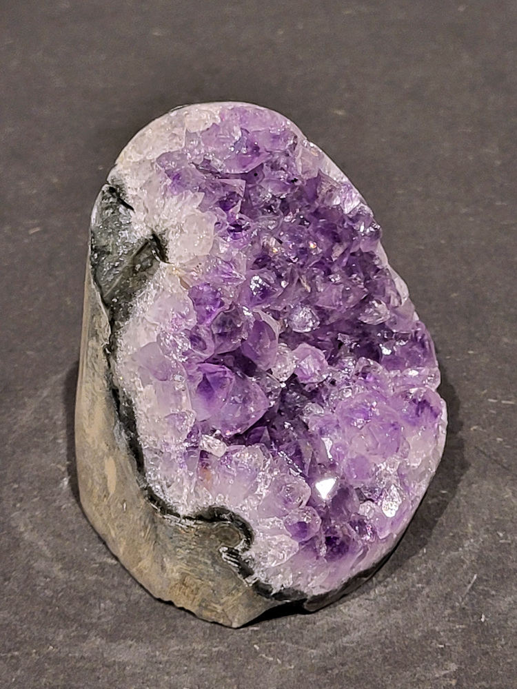 Amethist druzy, 0,5kg, 19,- euro, nr.26


Beschrijving Amethist.
Amethist is een paarse variëteit van kwarts, bekend om zijn kalmerende en spirituele eigenschappen. De kleur varieert van licht lila tot diep violet en wordt veroorzaakt door sporen van ijzer en andere elementen. Amethist wordt al eeuwenlang gewaardeerd, zowel vanwege zijn esthetische schoonheid als zijn vermeende genezende en beschermende krachten. 
Amethist is een kwartskristal, vaak te vinden in geodes (holtes in gesteente) of als afzonderlijke kristallen. 
De kleur varieert van lichtpaars tot diep violet, soms met roze of blauwe tinten. 
De kleurintensiteit kan variëren, waarbij donkerdere amethisten vaak als kwalitatief worden beschouwd. 
Soms vertoont amethist dichroïsme, waarbij je verschillende kleuren kunt zien wanneer je de steen in het licht draait. 

Vindplaatsen:
Amethist wordt gevonden in verschillende delen van de wereld, waaronder Brazilië, Uruguay, Zambia, Madagaskar, Rusland en Canada.
Het wordt vaak gevonden in bergachtige gebieden. 

Gebruik:
Amethist wordt gebruikt in sieraden, decoratieve objecten en als helende steen. 
Het wordt vaak gedragen als hanger, ring of armband, of geplaatst in ruimtes om de energie te zuiveren. 
Amethist wordt ook gebruikt in meditatie en andere spirituele praktijken. 