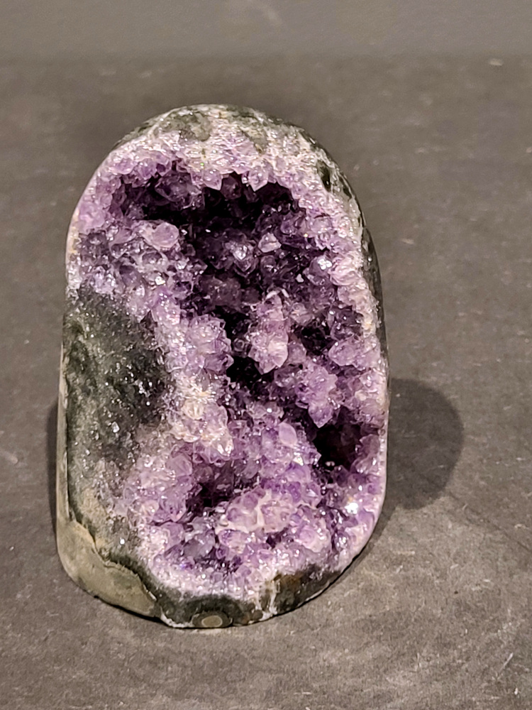 Amethist druzy, 0,5kg, 19,- euro, nr.53

Beschrijving Amethist.
Amethist is een paarse variëteit van kwarts, bekend om zijn kalmerende en spirituele eigenschappen. De kleur varieert van licht lila tot diep violet en wordt veroorzaakt door sporen van ijzer en andere elementen. Amethist wordt al eeuwenlang gewaardeerd, zowel vanwege zijn esthetische schoonheid als zijn vermeende genezende en beschermende krachten. 
Amethist is een kwartskristal, vaak te vinden in geodes (holtes in gesteente) of als afzonderlijke kristallen. 
De kleur varieert van lichtpaars tot diep violet, soms met roze of blauwe tinten. 
De kleurintensiteit kan variëren, waarbij donkerdere amethisten vaak als kwalitatief worden beschouwd. 
Soms vertoont amethist dichroïsme, waarbij je verschillende kleuren kunt zien wanneer je de steen in het licht draait. 

Vindplaatsen:
Amethist wordt gevonden in verschillende delen van de wereld, waaronder Brazilië, Uruguay, Zambia, Madagaskar, Rusland en Canada.
Het wordt vaak gevonden in bergachtige gebieden. 

Gebruik:
Amethist wordt gebruikt in sieraden, decoratieve objecten en als helende steen. 
Het wordt vaak gedragen als hanger, ring of armband, of geplaatst in ruimtes om de energie te zuiveren. 
Amethist wordt ook gebruikt in meditatie en andere spirituele praktijken. 