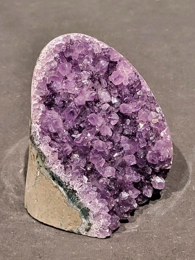 Amethist druzy, 0,6kg, 23,- euro, nr.49

Beschrijving Amethist.
Amethist is een paarse variëteit van kwarts, bekend om zijn kalmerende en spirituele eigenschappen. De kleur varieert van licht lila tot diep violet en wordt veroorzaakt door sporen van ijzer en andere elementen. Amethist wordt al eeuwenlang gewaardeerd, zowel vanwege zijn esthetische schoonheid als zijn vermeende genezende en beschermende krachten. 
Amethist is een kwartskristal, vaak te vinden in geodes (holtes in gesteente) of als afzonderlijke kristallen. 
De kleur varieert van lichtpaars tot diep violet, soms met roze of blauwe tinten. 
De kleurintensiteit kan variëren, waarbij donkerdere amethisten vaak als kwalitatief worden beschouwd. 
Soms vertoont amethist dichroïsme, waarbij je verschillende kleuren kunt zien wanneer je de steen in het licht draait. 

Vindplaatsen:
Amethist wordt gevonden in verschillende delen van de wereld, waaronder Brazilië, Uruguay, Zambia, Madagaskar, Rusland en Canada.
Het wordt vaak gevonden in bergachtige gebieden. 

Gebruik:
Amethist wordt gebruikt in sieraden, decoratieve objecten en als helende steen. 
Het wordt vaak gedragen als hanger, ring of armband, of geplaatst in ruimtes om de energie te zuiveren. 
Amethist wordt ook gebruikt in meditatie en andere spirituele praktijken. 