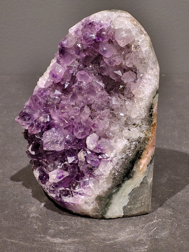 Amethist druzy, 1,1kg, 43,- euro, nr.36

Beschrijving Amethist.
Amethist is een paarse variëteit van kwarts, bekend om zijn kalmerende en spirituele eigenschappen. De kleur varieert van licht lila tot diep violet en wordt veroorzaakt door sporen van ijzer en andere elementen. Amethist wordt al eeuwenlang gewaardeerd, zowel vanwege zijn esthetische schoonheid als zijn vermeende genezende en beschermende krachten. 
Amethist is een kwartskristal, vaak te vinden in geodes (holtes in gesteente) of als afzonderlijke kristallen. 
De kleur varieert van lichtpaars tot diep violet, soms met roze of blauwe tinten. 
De kleurintensiteit kan variëren, waarbij donkerdere amethisten vaak als kwalitatief worden beschouwd. 
Soms vertoont amethist dichroïsme, waarbij je verschillende kleuren kunt zien wanneer je de steen in het licht draait. 

Vindplaatsen:
Amethist wordt gevonden in verschillende delen van de wereld, waaronder Brazilië, Uruguay, Zambia, Madagaskar, Rusland en Canada.
Het wordt vaak gevonden in bergachtige gebieden. 

Gebruik:
Amethist wordt gebruikt in sieraden, decoratieve objecten en als helende steen. 
Het wordt vaak gedragen als hanger, ring of armband, of geplaatst in ruimtes om de energie te zuiveren. 
Amethist wordt ook gebruikt in meditatie en andere spirituele praktijken. 