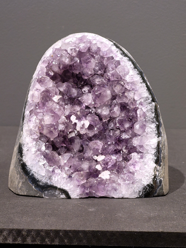Amethist druzy, 1,6kg, 62,- euro, nr. 43

Beschrijving Amethist.
Amethist is een paarse variëteit van kwarts, bekend om zijn kalmerende en spirituele eigenschappen. De kleur varieert van licht lila tot diep violet en wordt veroorzaakt door sporen van ijzer en andere elementen. Amethist wordt al eeuwenlang gewaardeerd, zowel vanwege zijn esthetische schoonheid als zijn vermeende genezende en beschermende krachten. 
Amethist is een kwartskristal, vaak te vinden in geodes (holtes in gesteente) of als afzonderlijke kristallen. 
De kleur varieert van lichtpaars tot diep violet, soms met roze of blauwe tinten. 
De kleurintensiteit kan variëren, waarbij donkerdere amethisten vaak als kwalitatief worden beschouwd. 
Soms vertoont amethist dichroïsme, waarbij je verschillende kleuren kunt zien wanneer je de steen in het licht draait. 

Vindplaatsen:
Amethist wordt gevonden in verschillende delen van de wereld, waaronder Brazilië, Uruguay, Zambia, Madagaskar, Rusland en Canada.
Het wordt vaak gevonden in bergachtige gebieden. 

Gebruik:
Amethist wordt gebruikt in sieraden, decoratieve objecten en als helende steen. 
Het wordt vaak gedragen als hanger, ring of armband, of geplaatst in ruimtes om de energie te zuiveren. 
Amethist wordt ook gebruikt in meditatie en andere spirituele praktijken. 