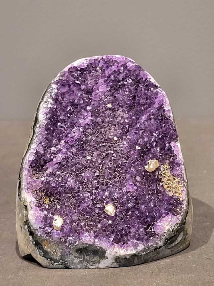 Amethist druzy, 1kg, 40,- euro, nr. 42

Beschrijving Amethist.
Amethist is een paarse variëteit van kwarts, bekend om zijn kalmerende en spirituele eigenschappen. De kleur varieert van licht lila tot diep violet en wordt veroorzaakt door sporen van ijzer en andere elementen. Amethist wordt al eeuwenlang gewaardeerd, zowel vanwege zijn esthetische schoonheid als zijn vermeende genezende en beschermende krachten. 
Amethist is een kwartskristal, vaak te vinden in geodes (holtes in gesteente) of als afzonderlijke kristallen. 
De kleur varieert van lichtpaars tot diep violet, soms met roze of blauwe tinten. 
De kleurintensiteit kan variëren, waarbij donkerdere amethisten vaak als kwalitatief worden beschouwd. 
Soms vertoont amethist dichroïsme, waarbij je verschillende kleuren kunt zien wanneer je de steen in het licht draait. 

Vindplaatsen:
Amethist wordt gevonden in verschillende delen van de wereld, waaronder Brazilië, Uruguay, Zambia, Madagaskar, Rusland en Canada.
Het wordt vaak gevonden in bergachtige gebieden. 

Gebruik:
Amethist wordt gebruikt in sieraden, decoratieve objecten en als helende steen. 
Het wordt vaak gedragen als hanger, ring of armband, of geplaatst in ruimtes om de energie te zuiveren. 
Amethist wordt ook gebruikt in meditatie en andere spirituele praktijken. 