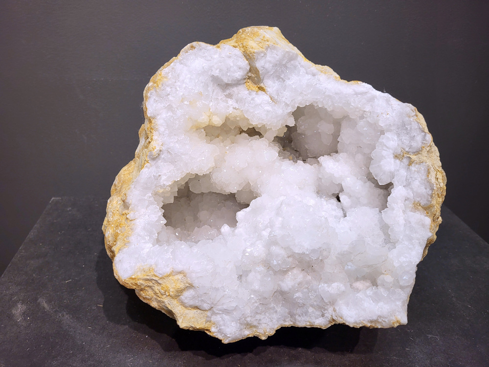 Bergkristal, Geode, Cluster, 19,5kg, 228,- euro, nr. 37

Beschrijving Bergkristal.

Bergkristal is een heldere, kleurloze variëteit van kwarts en is een van de meest voorkomende edelstenen. Het staat bekend om zijn glasachtige glans en wordt gewaardeerd om zijn zuivere, krachtige energie en wordt vaak gebruikt in sieraden, meditatie en heling. 
Eigenschappen en gebruik:
Uiterlijk:
Bergkristal is meestal kleurloos en transparant, maar kan ook melkachtig wit zijn door insluitingen van lucht of water. 
Hardheid:
Het heeft een hardheid van 7 op de schaal van Mohs, wat betekent dat het vrij duurzaam is. 
Chemische samenstelling:
Bergkristal is siliciumdioxide (SiO2). 
Gebruik:
Sieraden: Het wordt vaak verwerkt in hangers, ringen, armbanden en andere sieraden. 
Meditatie en heling: Het wordt gebruikt om energie te zuiveren, te versterken en te balanceren, en wordt vaak ingezet bij meditaties en andere spirituele praktijken. 
Technologie: Kwarts, inclusief bergkristal, wordt gebruikt in elektronica vanwege zijn piezo-elektrische eigenschappen, zoals in quartz oscillatoren. 
Decoratie: Het wordt ook gebruikt voor decoratieve doeleinden, zoals beeldjes, stenen en andere ornamenten. 
Herkomst:
Bergkristal wordt op veel plaatsen in de wereld gevonden, zoals Brazilië, Madagaskar, de Himalaya en Zwitserland. 
Spirituele betekenis:
Zuivering en balans:
Bergkristal wordt vaak gezien als een steen die energieën zuivert en in balans brengt, zowel fysiek als energetisch. 
Heldere geest:
Het zou helderheid van geest bevorderen en helpen bij het loslaten van negatieve gedachten en emoties. 
Versterking van energie:
Bergkristal wordt vaak gebruikt om de energie van andere stenen te versterken. 
Bescherming:
In sommige culturen wordt bergkristal gezien als een beschermende steen die aura's beschermt tegen negatieve invloeden.