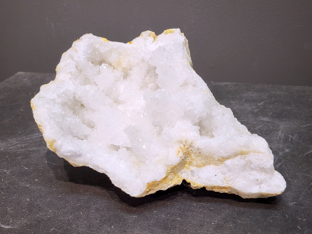 Bergkristal, Geode, Cluster, 2kg, 23,- euro, nr. 30

Beschrijving Bergkristal.

Bergkristal is een heldere, kleurloze variëteit van kwarts en is een van de meest voorkomende edelstenen. Het staat bekend om zijn glasachtige glans en wordt gewaardeerd om zijn zuivere, krachtige energie en wordt vaak gebruikt in sieraden, meditatie en heling. 
Eigenschappen en gebruik:
Uiterlijk:
Bergkristal is meestal kleurloos en transparant, maar kan ook melkachtig wit zijn door insluitingen van lucht of water. 
Hardheid:
Het heeft een hardheid van 7 op de schaal van Mohs, wat betekent dat het vrij duurzaam is. 
Chemische samenstelling:
Bergkristal is siliciumdioxide (SiO2). 
Gebruik:
Sieraden: Het wordt vaak verwerkt in hangers, ringen, armbanden en andere sieraden. 
Meditatie en heling: Het wordt gebruikt om energie te zuiveren, te versterken en te balanceren, en wordt vaak ingezet bij meditaties en andere spirituele praktijken. 
Technologie: Kwarts, inclusief bergkristal, wordt gebruikt in elektronica vanwege zijn piezo-elektrische eigenschappen, zoals in quartz oscillatoren. 
Decoratie: Het wordt ook gebruikt voor decoratieve doeleinden, zoals beeldjes, stenen en andere ornamenten. 
Herkomst:
Bergkristal wordt op veel plaatsen in de wereld gevonden, zoals Brazilië, Madagaskar, de Himalaya en Zwitserland. 
Spirituele betekenis:
Zuivering en balans:
Bergkristal wordt vaak gezien als een steen die energieën zuivert en in balans brengt, zowel fysiek als energetisch. 
Heldere geest:
Het zou helderheid van geest bevorderen en helpen bij het loslaten van negatieve gedachten en emoties. 
Versterking van energie:
Bergkristal wordt vaak gebruikt om de energie van andere stenen te versterken. 
Bescherming:
In sommige culturen wordt bergkristal gezien als een beschermende steen die aura's beschermt tegen negatieve invloeden. 