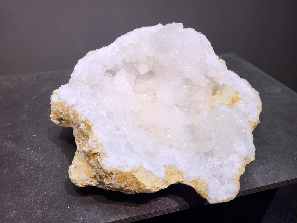 Bergkristal, Geode, Cluster, 6,1kg, 71,- euro, nr. 31.

Beschrijving Bergkristal.

Bergkristal is een heldere, kleurloze variëteit van kwarts en is een van de meest voorkomende edelstenen. Het staat bekend om zijn glasachtige glans en wordt gewaardeerd om zijn zuivere, krachtige energie en wordt vaak gebruikt in sieraden, meditatie en heling. 
Eigenschappen en gebruik:
Uiterlijk:
Bergkristal is meestal kleurloos en transparant, maar kan ook melkachtig wit zijn door insluitingen van lucht of water. 
Hardheid:
Het heeft een hardheid van 7 op de schaal van Mohs, wat betekent dat het vrij duurzaam is. 
Chemische samenstelling:
Bergkristal is siliciumdioxide (SiO2). 
Gebruik:
Sieraden: Het wordt vaak verwerkt in hangers, ringen, armbanden en andere sieraden. 
Meditatie en heling: Het wordt gebruikt om energie te zuiveren, te versterken en te balanceren, en wordt vaak ingezet bij meditaties en andere spirituele praktijken. 
Technologie: Kwarts, inclusief bergkristal, wordt gebruikt in elektronica vanwege zijn piezo-elektrische eigenschappen, zoals in quartz oscillatoren. 
Decoratie: Het wordt ook gebruikt voor decoratieve doeleinden, zoals beeldjes, stenen en andere ornamenten. 
Herkomst:
Bergkristal wordt op veel plaatsen in de wereld gevonden, zoals Brazilië, Madagaskar, de Himalaya en Zwitserland. 
Spirituele betekenis:
Zuivering en balans:
Bergkristal wordt vaak gezien als een steen die energieën zuivert en in balans brengt, zowel fysiek als energetisch. 
Heldere geest:
Het zou helderheid van geest bevorderen en helpen bij het loslaten van negatieve gedachten en emoties. 
Versterking van energie:
Bergkristal wordt vaak gebruikt om de energie van andere stenen te versterken. 
Bescherming:
In sommige culturen wordt bergkristal gezien als een beschermende steen die aura's beschermt tegen negatieve invloeden.