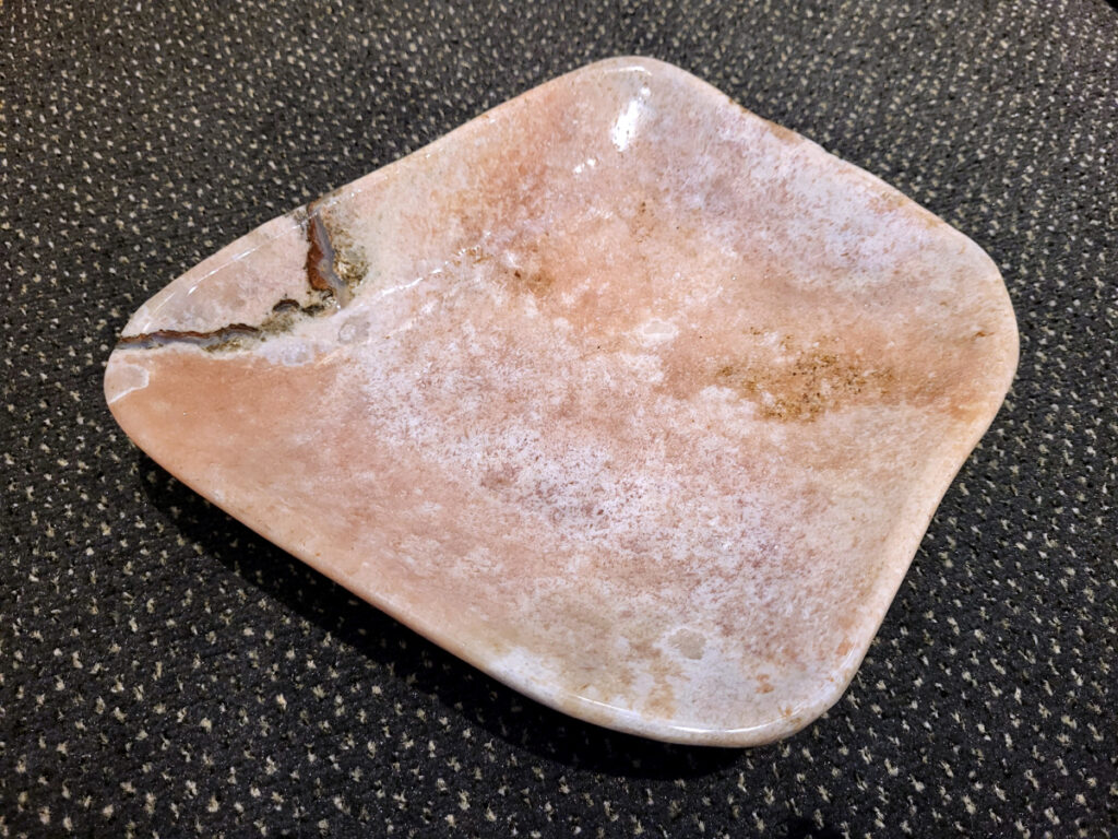 Chalcedoon, roze Amethist, schaal, 2,7kg, 145,- euro, nr.62

Chalcedoon, ook wel genoemd Roze Amethist

Chalcedoon is een edelsteen die behoort tot de kwartsfamilie en bekend staat om zijn zachte, wasachtige glans en diverse kleuren. Het is een microkristallijne vorm van kwarts, vaak in wit, grijs, blauw, geel, bruin of rood. Chalcedoon wordt gewaardeerd om zijn spirituele eigenschappen, zoals het bevorderen van communicatie, evenwicht en creativiteit. 
Kenmerken en soorten:
Chalcedoon is een cryptokristal gelijnde  kwarts, wat betekent dat de kristallen zo klein zijn dat ze met het blote oog niet te zien zijn. 
Het heeft een hardheid van 6,5-7 op de schaal van Mohs. 
Bekende variëteiten van chalcedoon zijn chrysopraas (appelgroen), carneool (roze tot rood) en sarder (bruin). 
Blauwe chalcedoon, met name Blue Lace Agate, staat bekend om zijn kalmerende werking en wordt geassocieerd met de keelchakra. 
Spirituele eigenschappen en werking:
Chalcedoon wordt gezien als de steen van communicatie en wordt vaak de "redenaarssteen" genoemd. 
Het bevordert helderheid van geest, zelfvertrouwen en moed om gevoelens te uiten. 
Chalcedoon kan helpen bij het loslaten van onderdrukte emoties en het vinden van innerlijke rust. 
Het wordt ook in verband gebracht met creativiteit en het vermogen om ideeën om te zetten in daden. 
Sommige geloven dat chalcedoon het keelchakra activeert en helpt bij problemen met de keel, stembanden en schildklier. 
Fysieke werking:
Chalcedoon wordt verondersteld reinigende, verkoelende en ontstekingsremmende eigenschappen te hebben.
Het kan helpen bij koorts, verkoudheid, ademhalingsproblemen en het versterken van het immuunsysteem. 
Chalcedoon wordt ook in verband gebracht met een positieve werking op de bloedsomloop, vochtophoping en de productie van insuline.
Overige:
Chalcedoon komt voor in verschillende delen van de wereld, waaronder Brazilië, Madagaskar, India en Uruguay. 
In de oudheid werd chalcedoon al gebruikt voor amuletten, zegels en sieraden.