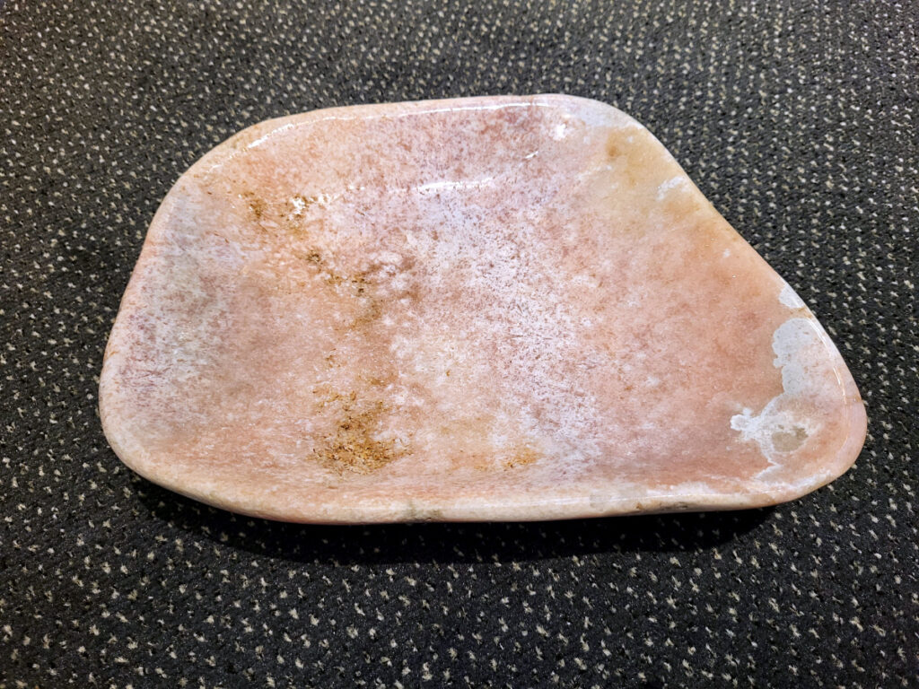Chalcedoon, roze Amethist, schaal, 2,8kg, 150,- euro

Chalcedoon, ook wel genoemd Roze Amethist

Chalcedoon is een edelsteen die behoort tot de kwartsfamilie en bekend staat om zijn zachte, wasachtige glans en diverse kleuren. Het is een microkristallijne vorm van kwarts, vaak in wit, grijs, blauw, geel, bruin of rood. Chalcedoon wordt gewaardeerd om zijn spirituele eigenschappen, zoals het bevorderen van communicatie, evenwicht en creativiteit. 
Kenmerken en soorten:
Chalcedoon is een cryptokristal gelijnde  kwarts, wat betekent dat de kristallen zo klein zijn dat ze met het blote oog niet te zien zijn. 
Het heeft een hardheid van 6,5-7 op de schaal van Mohs. 
Bekende variëteiten van chalcedoon zijn chrysopraas (appelgroen), carneool (roze tot rood) en sarder (bruin). 
Blauwe chalcedoon, met name Blue Lace Agate, staat bekend om zijn kalmerende werking en wordt geassocieerd met de keelchakra. 
Spirituele eigenschappen en werking:
Chalcedoon wordt gezien als de steen van communicatie en wordt vaak de "redenaarssteen" genoemd. 
Het bevordert helderheid van geest, zelfvertrouwen en moed om gevoelens te uiten. 
Chalcedoon kan helpen bij het loslaten van onderdrukte emoties en het vinden van innerlijke rust. 
Het wordt ook in verband gebracht met creativiteit en het vermogen om ideeën om te zetten in daden. 
Sommige geloven dat chalcedoon het keelchakra activeert en helpt bij problemen met de keel, stembanden en schildklier. 
Fysieke werking:
Chalcedoon wordt verondersteld reinigende, verkoelende en ontstekingsremmende eigenschappen te hebben.
Het kan helpen bij koorts, verkoudheid, ademhalingsproblemen en het versterken van het immuunsysteem. 
Chalcedoon wordt ook in verband gebracht met een positieve werking op de bloedsomloop, vochtophoping en de productie van insuline.
Overige:
Chalcedoon komt voor in verschillende delen van de wereld, waaronder Brazilië, Madagaskar, India en Uruguay. 
In de oudheid werd chalcedoon al gebruikt voor amuletten, zegels en sieraden.