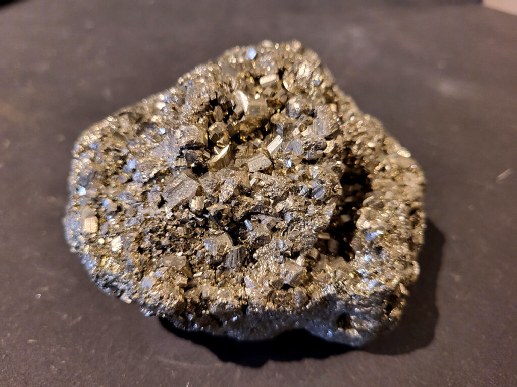 Pyriet, 0,9kg, 32,- euro, nr. 3

Pyriet, ook wel bekend als klatergoud. Het is een mineraal van ijzer en zwavel met een goudgele, metaalachtige glans, wat het soms doet lijken op goud. De naam komt van het Griekse woord voor 'vuur' ,
 omdat het vonken geeft als je het ergens tegenaan slaat. Het wordt industrieel gebruikt voor de productie van zwavelzuur en als decoratieve steen, terwijl het in de oudheid diende als vuursteen. 
Kenmerken 
Uiterlijk: Goudgeel met een metaalachtige glans. De kristallen zijn vaak kubusvormig, maar kunnen ook andere vormen hebben.
Naam: Afgeleid van het Griekse woord voor 'vuur', vanwege het vonkend effect bij impact.
Bijnaam: Ook wel "klatergoud" of "goud der dwazen" genoemd vanwege de gelijkenis met echt goud. 
Toepassingen en gebruik 
Industrie: Het is een belangrijke bron voor de productie van zwavelzuur, dat onder andere wordt gebruikt in kunstmest en olieraffinage.
Geschiedenis: In de oudheid werd het gebruikt als vuursteen om vuur te maken.
Decoratie en sieraden: Vanwege zijn goudachtige uiterlijk wordt het veel gebruikt in sieraden en decoratieve objecten.
Wetenschap: Het dient als indicator voor geologische processen en wordt gebruikt in mineralogisch onderzoek. 
Onderscheid met goud 
Textuur: Ruwe pyrietkristallen hebben scherpere randen dan ruw goud.
Kleur: Pyriet heeft vaker een koperachtige tint, terwijl echt goud een helderder, geelgouden kleur heeft.
Hardheid: Pyriet is harder dan goud (hardheid van 6-6,5 versus 2,5).
Dichtheid: Pyriet is lichter in gewicht dan goud.