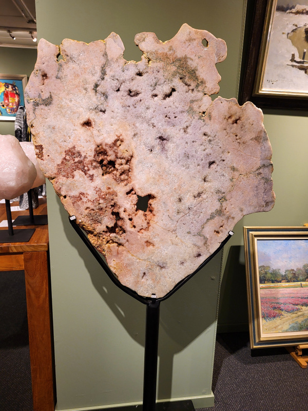 Roze Amethist, Chalcedoon, 33kg, 145cm hoog, 75cm doorsnee, 1150,- euro, nr. 23

Chalcedoon, ook wel genoemd Roze Amethist

Chalcedoon is een edelsteen die behoort tot de kwartsfamilie en bekend staat om zijn zachte, wasachtige glans en diverse kleuren. Het is een microkristallijne vorm van kwarts, vaak in wit, grijs, blauw, geel, bruin of rood. Chalcedoon wordt gewaardeerd om zijn spirituele eigenschappen, zoals het bevorderen van communicatie, evenwicht en creativiteit. 
Kenmerken en soorten:
Chalcedoon is een cryptokristal gelijnde  kwarts, wat betekent dat de kristallen zo klein zijn dat ze met het blote oog niet te zien zijn. 
Het heeft een hardheid van 6,5-7 op de schaal van Mohs. 
Bekende variëteiten van chalcedoon zijn chrysopraas (appelgroen), carneool (roze tot rood) en sarder (bruin). 
Blauwe chalcedoon, met name Blue Lace Agate, staat bekend om zijn kalmerende werking en wordt geassocieerd met de keelchakra. 
Spirituele eigenschappen en werking:
Chalcedoon wordt gezien als de steen van communicatie en wordt vaak de "redenaarssteen" genoemd. 
Het bevordert helderheid van geest, zelfvertrouwen en moed om gevoelens te uiten. 
Chalcedoon kan helpen bij het loslaten van onderdrukte emoties en het vinden van innerlijke rust. 
Het wordt ook in verband gebracht met creativiteit en het vermogen om ideeën om te zetten in daden. 
Sommige geloven dat chalcedoon het keelchakra activeert en helpt bij problemen met de keel, stembanden en schildklier. 
Fysieke werking:
Chalcedoon wordt verondersteld reinigende, verkoelende en ontstekingsremmende eigenschappen te hebben.
Het kan helpen bij koorts, verkoudheid, ademhalingsproblemen en het versterken van het immuunsysteem. 
Chalcedoon wordt ook in verband gebracht met een positieve werking op de bloedsomloop, vochtophoping en de productie van insuline.
Overige:
Chalcedoon komt voor in verschillende delen van de wereld, waaronder Brazilië, Madagaskar, India en Uruguay. 
In de oudheid werd chalcedoon al gebruikt voor amuletten, zegels en sieraden.