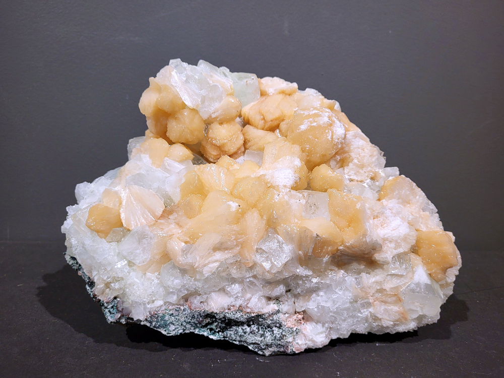 Stilbiet Cluster, 8kg, 160,- euro, nr. 10
Stilbiet (ook wel stilbite genoemd), vaak gevonden samen met apofyliet in Indiase geodes.
Uiterlijk:
Perzik- tot crème-witte kleur,
Glanzende, waaier- of bloemvormige kristalstructuur,
Zachte, zijdeachtige glans (bijna parelmoerachtig),
al die kenmerken passen heel goed bij stilbiet.
De ronde, lichtgrijze korrelige bol bovenop kan een heulandiet- of chalcedoon-vorming zijn die samen met de stilbiet is gegroeid.
Energetische betekenis:
Stilbiet hoort bij het hart en het kruinchakra is een zachte, troostende energie die helpt bij het loslaten van oude patronen en het verbinden met hogere leiding.
Ze ondersteunt intuïtie, dromen en zachtheid in relaties — een heel liefdevolle steen om in huis te hebben, vooral bij healing- of slaapruimtes.