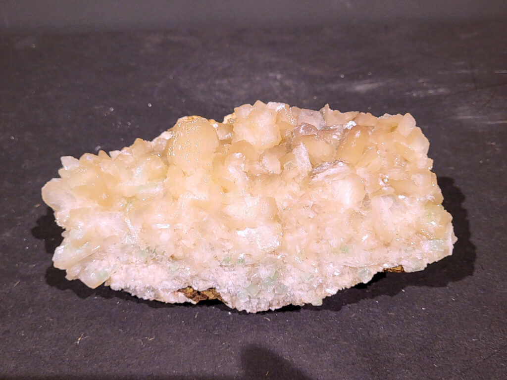 Stilbiet Cluster met Apofyliet, 1,2kg, 35,- euro, nr. 13

Stilbiet,
Beschrijving:
De waaier- of bundelvormige kristallen met een zijdeachtige glans en soms lichtgroen-geelachtige gloed zijn typisch voor stilbiet.
De helder witte tot doorschijnende kubusvormige kristallen aan de basis zijn apofyliet.
De gele of groenige zweem kan komen van een lichte epidoot- of prehniet-insluiting, of een natuurlijke oxidatie aan het oppervlak.
Energetische werking:
Stilbiet opent het hart en helpt loslaten van zorgen; het is zacht, troostend en bevordert vertrouwen in de loop van het leven.
Apofyliet versterkt intuïtie, helderheid en spirituele verbinding — een “lichtbrenger” die energie zuivert in een ruimte.
Samen vormen ze een kalmerende, hoogtrillende combinatie die ideaal is voor meditatie, healingruimtes of slaapkamers (voor rust en inzicht).
Zorgtip:
Houd ze uit direct zonlicht (kan verkleuren) en reinig liever met klank, maanlicht of wierook in plaats van water — apofyliet lost iets op bij langdurig vocht.

Een stilbiet (ook wel stilbite genoemd), wordt vaak gevonden samen met apofyliet in Indiase geodes.
Uiterlijk:
De perzik- tot crème-witte kleur,
De glanzende, waaier- of bloemvormige kristalstructuur,
De zachte, zijdeachtige glans (bijna parelmoerachtig),
al die kenmerken passen heel goed bij stilbiet.
De ronde, lichtgrijze korrelige bol bovenop kan een heulandiet- of chalcedoon-vorming zijn die samen met de stilbiet is gegroeid.
Energetische betekenis:
Stilbiet hoort bij het hart en het kruinchakra — een zachte, troostende energie die helpt bij het loslaten van oude patronen en het verbinden met hogere leiding.
Ze ondersteunt intuïtie, dromen en zachtheid in relaties — een heel liefdevolle steen om in huis te hebben, vooral bij healing- of slaapruimtes.