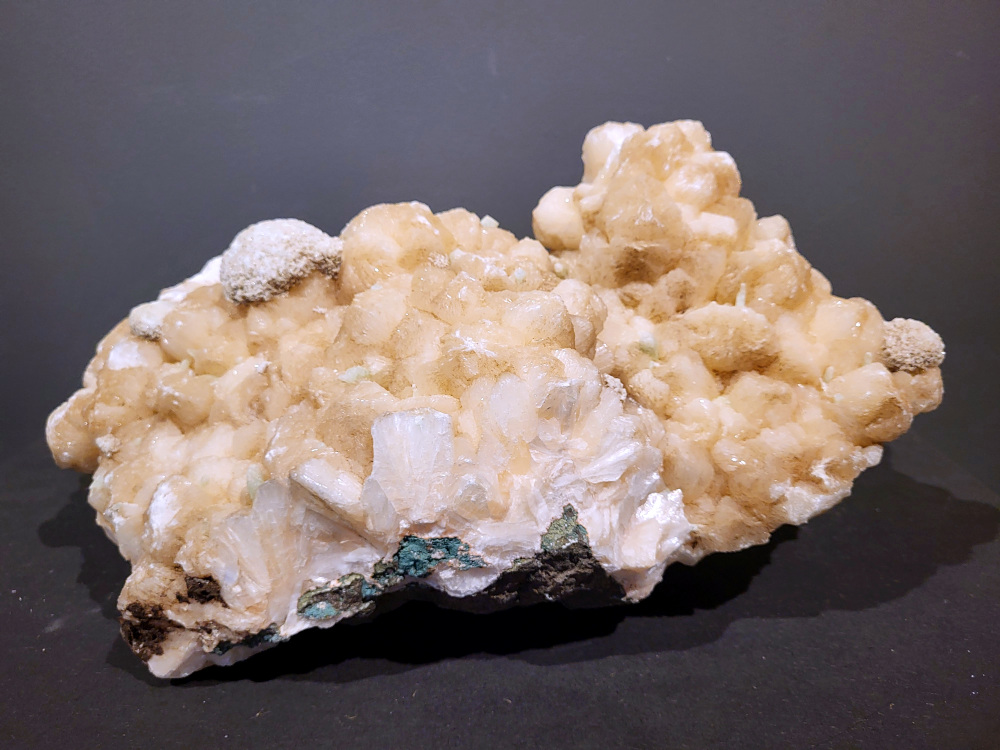 Stilbiet Cluster met Apofyliet, 15,2kg, 295,- euro, nr. 12

Stilbiet (ook wel stilbite genoemd), vaak gevonden samen met apofyliet in Indiase geodes.
Uiterlijk:
Perzik- tot crème-witte kleur,
Glanzende, waaier- of bloemvormige kristalstructuur,
Zachte, zijdeachtige glans (bijna parelmoerachtig),
al die kenmerken passen heel goed bij stilbiet.
De ronde, lichtgrijze korrelige bol bovenop kan een heulandiet- of chalcedoon-vorming zijn die samen met de stilbiet is gegroeid.
Energetische betekenis:
Stilbiet hoort bij het hart en het kruinchakra is een zachte, troostende energie die helpt bij het loslaten van oude patronen en het verbinden met hogere leiding.
Ze ondersteunt intuïtie, dromen en zachtheid in relaties — een heel liefdevolle steen om in huis te hebben, vooral bij healing- of slaapruimtes.