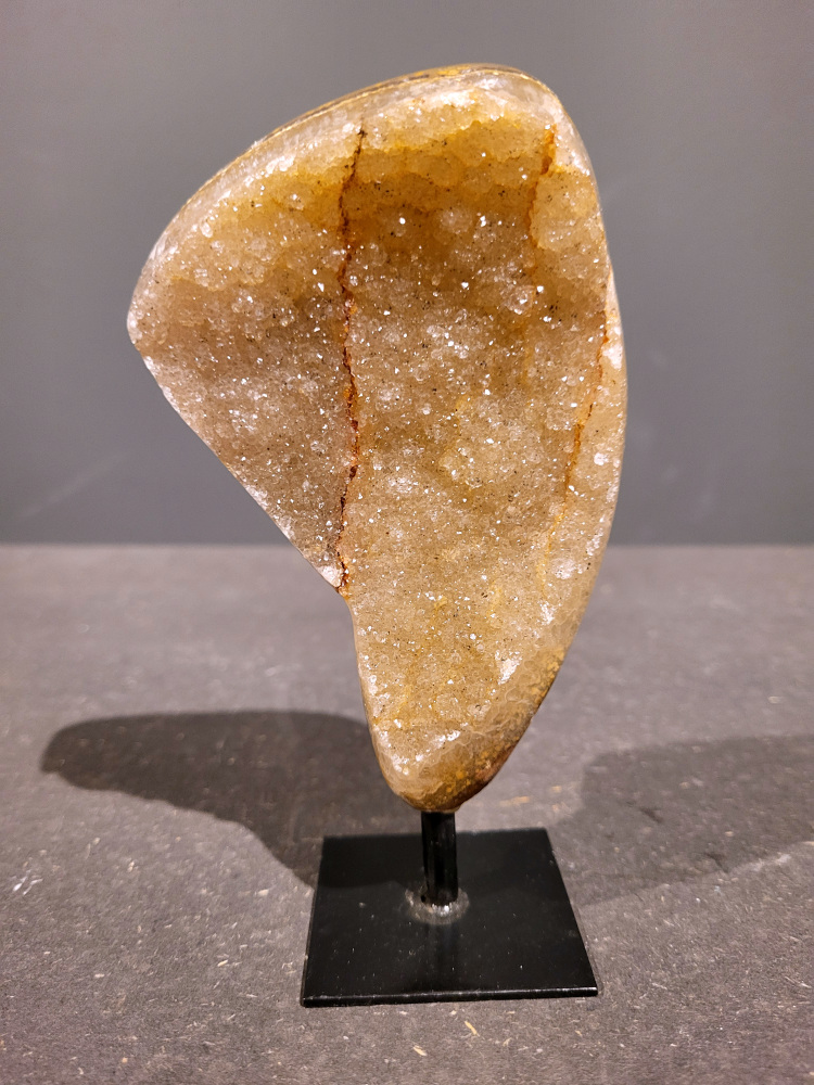 <strong>Agaat op standaard, 0,4kg, 16cm hoog, 22,- euro, nr. 41</strong>

<strong>Beschrijving Agaat.</strong>

Agaat is een veelzijdige edelsteen die bekend staat om zijn prachtige kleurbanden en patronen. Het is een variëteit van het mineraal kwarts, meer specifiek chalcedoon, en wordt vaak gebruikt in sieraden en als decoratieve steen. 
<strong>Algemene kenmerken:</strong>
Agaat is een microkristallijne vorm van kwarts, bestaande uit microscopisch kleine kristallen. 
<strong>Kleuren en patronen:</strong>
Agaat komt voor in vele kleuren, vaak met banden of lagen in verschillende tinten. 
Agaat is een populaire keuze voor het maken van kettingen, armbanden, ringen en andere sieraden vanwege de esthetische aantrekkingskracht en duurzaamheid. 
<strong>Spirituele eigenschappen:</strong>
Agaat wordt vaak geassocieerd met aardende, stabiliserende en beschermende eigenschappen. 
<strong>Helende werking:</strong>
Er wordt aangenomen dat agaat kan helpen bij het verminderen van stress, het bevorderen van emotioneel evenwicht en het versterken van het zelfvertrouwen. 
<strong>Verzorging van agaat:</strong>
Agaat is relatief gemakkelijk te onderhouden. Het kan worden gereinigd met lauw water, de rook van witte salie of palo santo, of door het op een hematiet- of bergkristal-cluster te plaatsen. 

<strong>-	Kunstgalerie-Arnold -</strong>