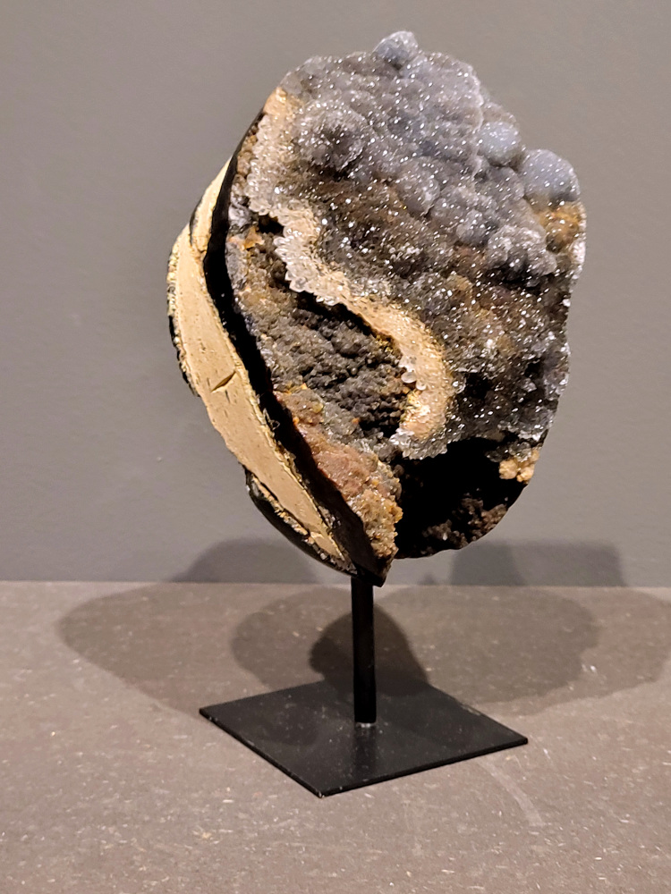 <strong>Agaat op standaard, 20cm hoog, 1,3kg, 67,- euro, nr. 20</strong>

Agaat is een veelzijdige edelsteen die bekend staat om zijn prachtige kleurbanden en patronen. Het is een variëteit van het mineraal kwarts, meer specifiek chalcedoon, en wordt vaak gebruikt in sieraden en als decoratieve steen. 
<strong>Algemene kenmerken:</strong>
Agaat is een microkristallijne vorm van kwarts, bestaande uit microscopisch kleine kristallen. 
<strong>Kleuren en patronen:</strong>
Agaat komt voor in vele kleuren, vaak met banden of lagen in verschillende tinten. 
Agaat is een populaire keuze voor het maken van kettingen, armbanden, ringen en andere sieraden vanwege de esthetische aantrekkingskracht en duurzaamheid. 
<strong>Spirituele eigenschappen:</strong>
Agaat wordt vaak geassocieerd met aardende, stabiliserende en beschermende eigenschappen. 
<strong>Helende werking:</strong>
Er wordt aangenomen dat agaat kan helpen bij het verminderen van stress, het bevorderen van emotioneel evenwicht en het versterken van het zelfvertrouwen. 
<strong>Verzorging van agaat:</strong>
Agaat is relatief gemakkelijk te onderhouden. Het kan worden gereinigd met lauw water, de rook van witte salie of palo santo, of door het op een hematiet- of bergkristal-cluster te plaatsen. 

<strong>-	Kunstgalerie-Arnold -</strong>