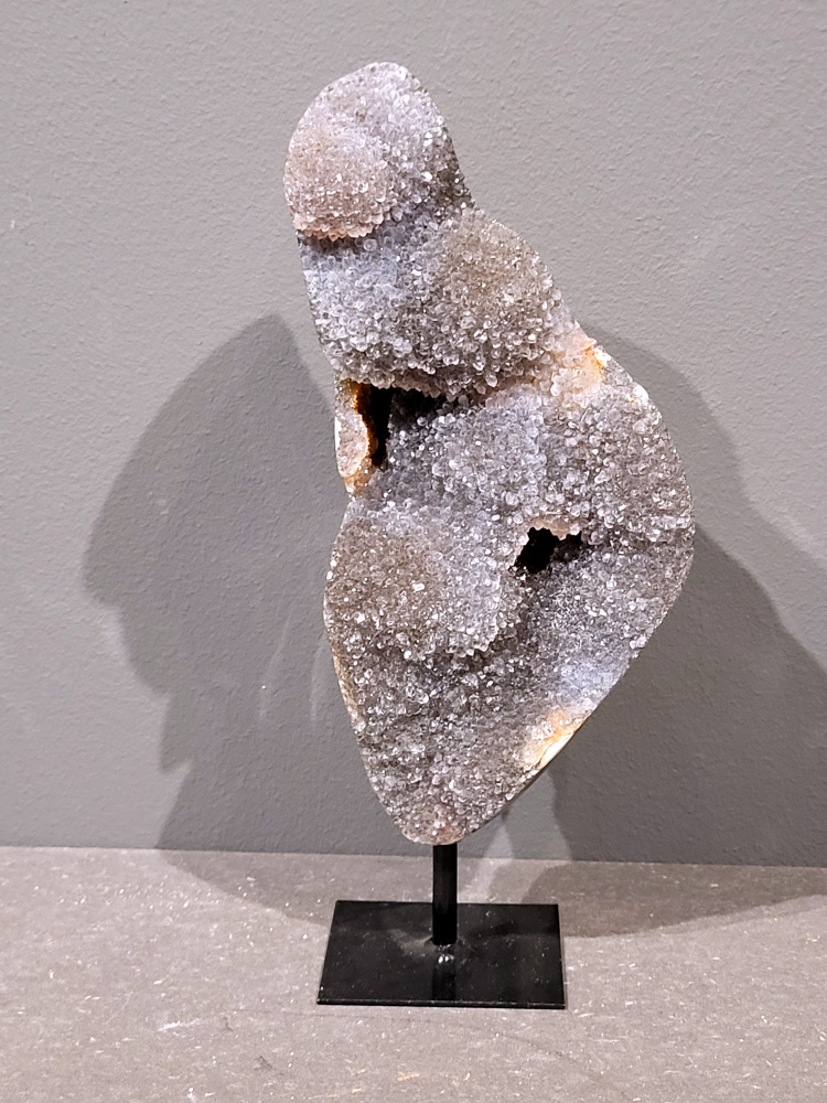 <strong>Agaat op standaard, 23cm hoog, 0,8 kg, 39,- euro, nr. 17</strong>

Agaat is een veelzijdige edelsteen die bekend staat om zijn prachtige kleurbanden en patronen. Het is een variëteit van het mineraal kwarts, meer specifiek chalcedoon, en wordt vaak gebruikt in sieraden en als decoratieve steen. 
<strong>Algemene kenmerken:</strong>
Agaat is een microkristallijne vorm van kwarts, bestaande uit microscopisch kleine kristallen. 
<strong>Kleuren en patronen:</strong>
Agaat komt voor in vele kleuren, vaak met banden of lagen in verschillende tinten. 
Agaat is een populaire keuze voor het maken van kettingen, armbanden, ringen en andere sieraden vanwege de esthetische aantrekkingskracht en duurzaamheid. 
<strong>Spirituele eigenschappen:</strong>
Agaat wordt vaak geassocieerd met aardende, stabiliserende en beschermende eigenschappen. 
<strong>Helende werking:</strong>
Er wordt aangenomen dat agaat kan helpen bij het verminderen van stress, het bevorderen van emotioneel evenwicht en het versterken van het zelfvertrouwen. 
<strong>Verzorging van agaat:</strong>
Agaat is relatief gemakkelijk te onderhouden. Het kan worden gereinigd met lauw water, de rook van witte salie of palo santo, of door het op een hematiet- of bergkristal-cluster te plaatsen. 

<strong>-	Kunstgalerie-Arnold -</strong>