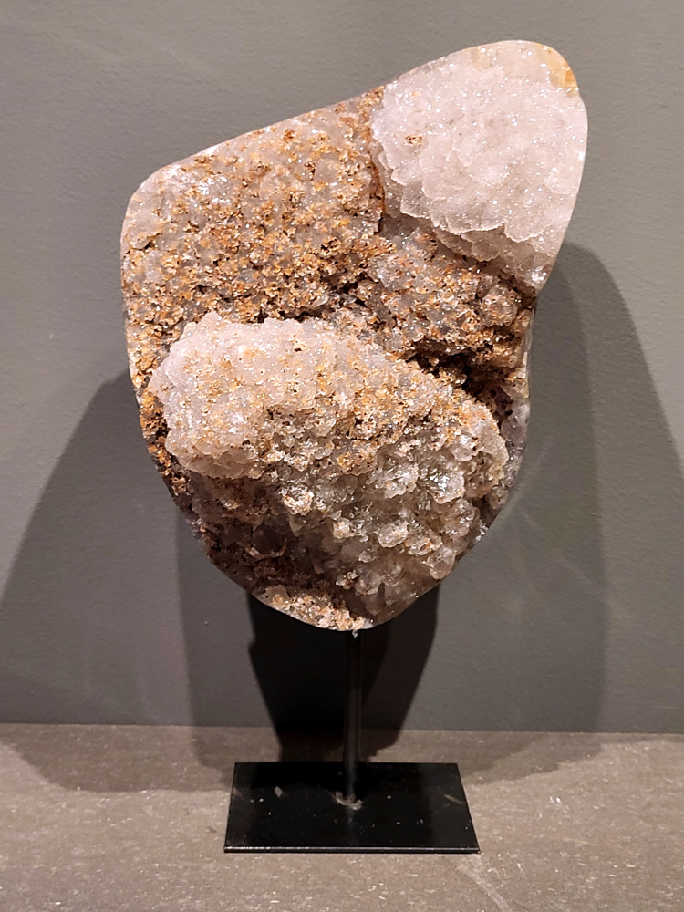 <strong>Agaat op standaard, 30cm hoog, 5,1 kg, 250,- euro, nr. 12</strong>

Agaat is een veelzijdige edelsteen die bekend staat om zijn prachtige kleurbanden en patronen. Het is een variëteit van het mineraal kwarts, meer specifiek chalcedoon, en wordt vaak gebruikt in sieraden en als decoratieve steen. 
<strong>Algemene kenmerken:</strong>
Agaat is een microkristallijne vorm van kwarts, bestaande uit microscopisch kleine kristallen. 
<strong>Kleuren en patronen:</strong>
Agaat komt voor in vele kleuren, vaak met banden of lagen in verschillende tinten. 
Agaat is een populaire keuze voor het maken van kettingen, armbanden, ringen en andere sieraden vanwege de esthetische aantrekkingskracht en duurzaamheid. 
<strong>Spirituele eigenschappen:</strong>
Agaat wordt vaak geassocieerd met aardende, stabiliserende en beschermende eigenschappen. 
<strong>Helende werking:</strong>
Er wordt aangenomen dat agaat kan helpen bij het verminderen van stress, het bevorderen van emotioneel evenwicht en het versterken van het zelfvertrouwen. 
<strong>Verzorging van agaat:</strong>
Agaat is relatief gemakkelijk te onderhouden. Het kan worden gereinigd met lauw water, de rook van witte salie of palo santo, of door het op een hematiet- of bergkristal-cluster te plaatsen. 

<strong>-	Kunstgalerie-Arnold -</strong>