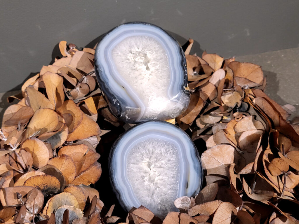 <strong>Agaat, paar, 1,9kg, 95,- euro, nr. 27</strong>

<strong>Beschrijving Agaat.</strong>

Agaat is een veelzijdige edelsteen die bekend staat om zijn prachtige kleurbanden en patronen. Het is een variëteit van het mineraal kwarts, meer specifiek chalcedoon, en wordt vaak gebruikt in sieraden en als decoratieve steen. 
<strong>Algemene kenmerken:</strong>
Agaat is een microkristallijne vorm van kwarts, bestaande uit microscopisch kleine kristallen. 
<strong>Kleuren en patronen:</strong>
Agaat komt voor in vele kleuren, vaak met banden of lagen in verschillende tinten. 
Agaat is een populaire keuze voor het maken van kettingen, armbanden, ringen en andere sieraden vanwege de esthetische aantrekkingskracht en duurzaamheid. 
<strong>Spirituele eigenschappen:</strong>
Agaat wordt vaak geassocieerd met aardende, stabiliserende en beschermende eigenschappen. 
<strong>Helende werking:</strong>
Er wordt aangenomen dat agaat kan helpen bij het verminderen van stress, het bevorderen van emotioneel evenwicht en het versterken van het zelfvertrouwen. 
<strong>Verzorging van agaat:</strong>
Agaat is relatief gemakkelijk te onderhouden. Het kan worden gereinigd met lauw water, de rook van witte salie of palo santo, of door het op een hematiet- of bergkristal-cluster te plaatsen. 

<strong>-	Kunstgalerie-Arnold -</strong>