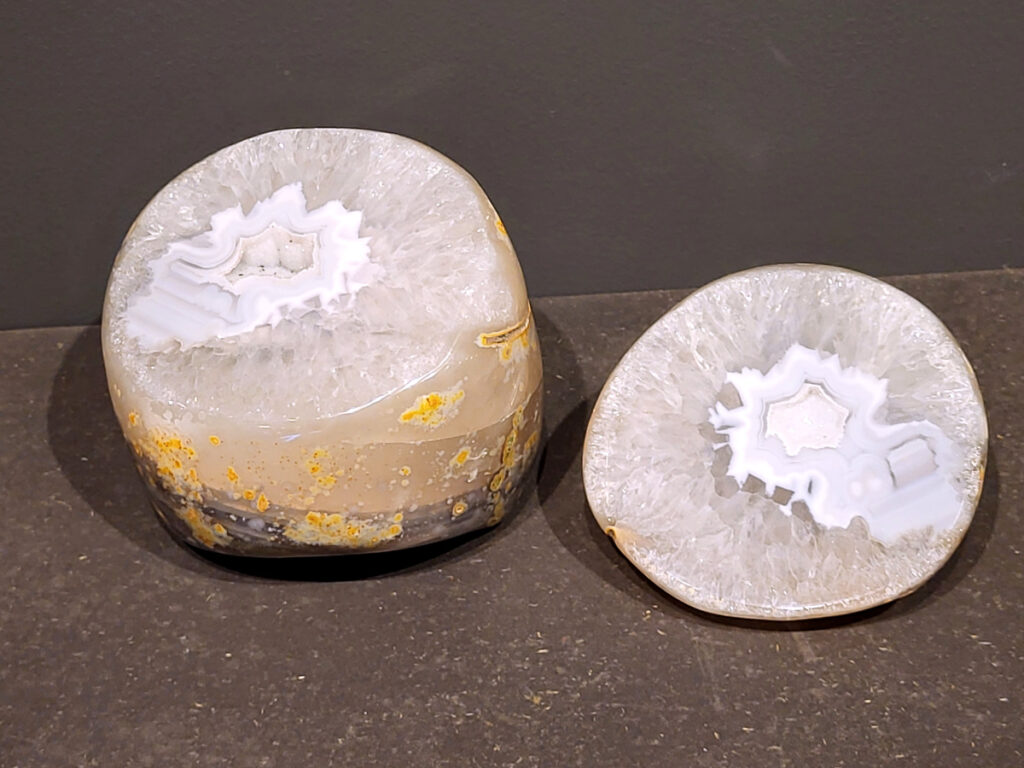 <strong>Agaat, paar, 3,9 kg, 194,- euro, nr. 21</strong>

Beschrijving Agaat.

Agaat is een veelzijdige edelsteen die bekend staat om zijn prachtige kleurbanden en patronen. Het is een variëteit van het mineraal kwarts, meer specifiek chalcedoon, en wordt vaak gebruikt in sieraden en als decoratieve steen. 
<strong>Algemene kenmerken:</strong>
Agaat is een microkristallijne vorm van kwarts, bestaande uit microscopisch kleine kristallen. 
<strong>Kleuren en patronen:</strong>
Agaat komt voor in vele kleuren, vaak met banden of lagen in verschillende tinten. 
Agaat is een populaire keuze voor het maken van kettingen, armbanden, ringen en andere sieraden vanwege de esthetische aantrekkingskracht en duurzaamheid. 
<strong>Spirituele eigenschappen:</strong>
Agaat wordt vaak geassocieerd met aardende, stabiliserende en beschermende eigenschappen. 
<strong>Helende werking:</strong>
Er wordt aangenomen dat agaat kan helpen bij het verminderen van stress, het bevorderen van emotioneel evenwicht en het versterken van het zelfvertrouwen. 
<strong>Verzorging van agaat:</strong>
Agaat is relatief gemakkelijk te onderhouden. Het kan worden gereinigd met lauw water, de rook van witte salie of palo santo, of door het op een hematiet- of bergkristal-cluster te plaatsen. 

<strong>-	Kunstgalerie-Arnold -</strong>