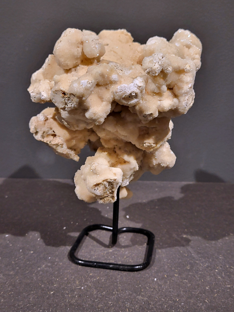 Calciet op standaard, 1,7kg, 21cm hoog, 33,- euro, nr. 53

Calciet is een veelvoorkomend mineraal dat voornamelijk bestaat uit calciumcarbonaat. Het komt in diverse kleuren en vormen voor en wordt in veel industrieën gebruikt, maar ook in de esoterie. 
Algemene kenmerken:
Samenstelling: Calciet bestaat voornamelijk uit calciumcarbonaat (CaCO3). 
Vorming: Het ontstaat door afzetting van calciumcarbonaat in water, maar ook door ophoping van schelpen en skeletten van zeedieren. 
Uiterlijk: Het heeft vaak een glasachtige glans, is doorzichtig tot doorschijnend en kan vele kleuren hebben, zoals geel, oranje, rood, bruin, blauw, groen, roze, wit en kleurloos. 
Hardheid: Calciet heeft een hardheid van 3 op de schaal van Mohs. 
Veelvoorkomend: Het is een van de meest voorkomende mineralen en is een hoofdbestanddeel van kalksteen, marmer en krijt. 
Esoterie:
In de edelsteentherapie wordt calciet gezien als een steen die energie versterkt, negatieve energieën verwijdert en spirituele groei bevordert. Verschillende kleuren calciet hebben specifieke eigenschappen, zoals gele calciet voor doorzettingsvermogen en moed, en mangano calciet voor emotionele heling. 
Specifieke calcietsoorten:
Gele Calciet: Staat bekend om het absorberen van negativiteit, het versterken van doorzettingsvermogen en het aantrekken van succes. 
Blauwe Calciet: Wordt geassocieerd met kalmering, communicatie en het loslaten van stress. 
Groene Calciet: Werkt op de hartchakra, bevordert liefde, compassie en emotionele heling. 
Mangano Calciet: Wordt gebruikt voor emotionele heling, het loslaten van oud verdriet en het versterken van zelfvertrouwen. 
Reiniging:
Calciet kan op verschillende manieren gereinigd worden, maar het is belangrijk om te weten dat sommige soorten, zoals gele calciet, niet goed tegen water kunnen. 
Andere reinigingsmethoden zijn bijvoorbeeld reinigen met edelstenenspray, op een Amethist of bergkristal leggen, of reinigen met selenite. 
Het is een steen die kan worden gebruikt voor energieversterking, emotionele heling en het bevorderen van spirituele groei, afhankelijk van de specifieke kleur en eigenschappen. 