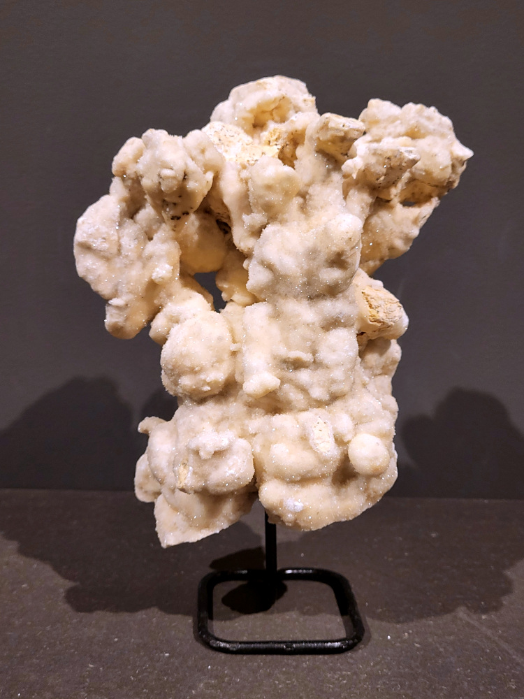 Calciet op standaard, 2,2kg, 25cm hoog, 40,- euro, nr. 54

Calciet is een veelvoorkomend mineraal dat voornamelijk bestaat uit calciumcarbonaat. Het komt in diverse kleuren en vormen voor en wordt in veel industrieën gebruikt, maar ook in de esoterie. 
Algemene kenmerken:
Samenstelling: Calciet bestaat voornamelijk uit calciumcarbonaat (CaCO3). 
Vorming: Het ontstaat door afzetting van calciumcarbonaat in water, maar ook door ophoping van schelpen en skeletten van zeedieren. 
Uiterlijk: Het heeft vaak een glasachtige glans, is doorzichtig tot doorschijnend en kan vele kleuren hebben, zoals geel, oranje, rood, bruin, blauw, groen, roze, wit en kleurloos. 
Hardheid: Calciet heeft een hardheid van 3 op de schaal van Mohs. 
Veelvoorkomend: Het is een van de meest voorkomende mineralen en is een hoofdbestanddeel van kalksteen, marmer en krijt. 
Esoterie:
In de edelsteentherapie wordt calciet gezien als een steen die energie versterkt, negatieve energieën verwijdert en spirituele groei bevordert. Verschillende kleuren calciet hebben specifieke eigenschappen, zoals gele calciet voor doorzettingsvermogen en moed, en mangano calciet voor emotionele heling. 
Specifieke calcietsoorten:
Gele Calciet: Staat bekend om het absorberen van negativiteit, het versterken van doorzettingsvermogen en het aantrekken van succes. 
Blauwe Calciet: Wordt geassocieerd met kalmering, communicatie en het loslaten van stress. 
Groene Calciet: Werkt op de hartchakra, bevordert liefde, compassie en emotionele heling. 
Mangano Calciet: Wordt gebruikt voor emotionele heling, het loslaten van oud verdriet en het versterken van zelfvertrouwen. 
Reiniging:
Calciet kan op verschillende manieren gereinigd worden, maar het is belangrijk om te weten dat sommige soorten, zoals gele calciet, niet goed tegen water kunnen. 
Andere reinigingsmethoden zijn bijvoorbeeld reinigen met edelstenenspray, op een Amethist of bergkristal leggen, of reinigen met selenite. 
Het is een steen die kan worden gebruikt voor energieversterking, emotionele heling en het bevorderen van spirituele groei, afhankelijk van de specifieke kleur en eigenschappen. 