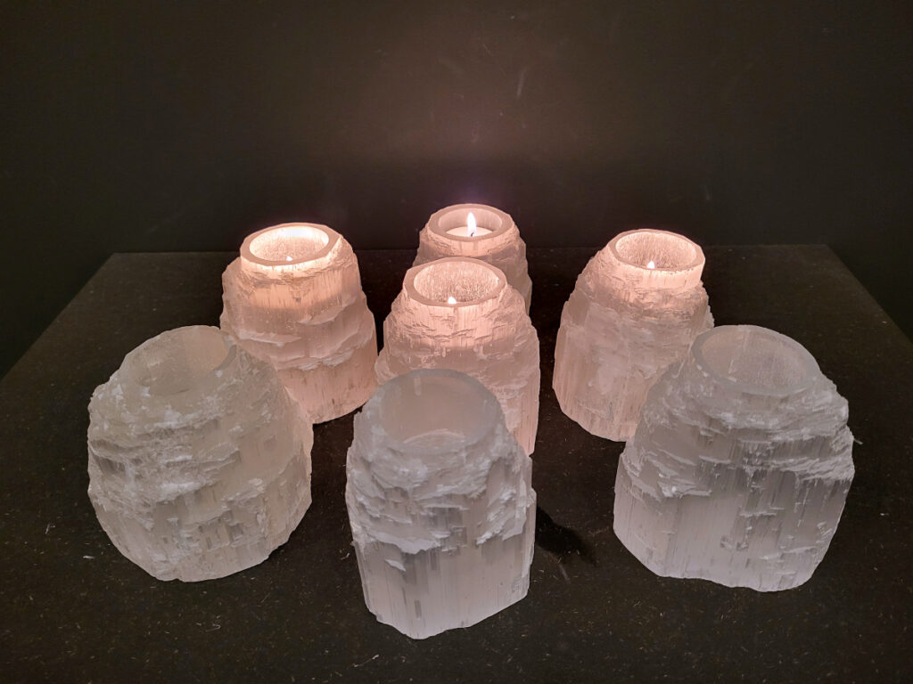 Seleniet, Waxine lichten, 11cm hoog, doorsnee 9 cm, 10,- euro, nr. 4

Seleniet is een vorm van gips, een mineraal met een vezelige structuur. Het staat bekend om zijn heldere, witte kleur en wordt vaak "satijnspaat" genoemd vanwege zijn glans. Seleniet kan ook andere kleuren hebben, zoals geel, oranje en rood. De naam "seleniet" komt van de Griekse maangodin Selene, vanwege de maanachtige glans van de steen.
Eigenschappen en kenmerken:
Kleur: Meestal wit, maar kan ook geel, oranje, rood, groen of blauw zijn.
Vorm: Vaak in lange, dunne kristallen, soms ook als woestijnrozen.
Textuur: Vezelig en glanzend, met een satijnachtige uitstraling.
Hardheid: 2 op de schaal van Mohs, wat betekent dat het zacht is en makkelijk kan krassen.
Vorming: Ontstaat door de verdamping van zoutwatermeren en -zeeën.
Spirituele en helende eigenschappen:
Seleniet wordt vaak gebruikt in spirituele praktijken en meditatie, vanwege de vermeende kalmerende en reinigende werking.
Het wordt vaak geassocieerd met het reinigen en opladen van andere edelstenen.
Seleniet zou helpen om negatieve energie te verwijderen, helderheid van geest te bevorderen en contact te maken met hogere bewustzijnsniveaus.
In de edelsteentherapie wordt seleniet gebruikt voor ontspanning en het loslaten van spanningen.
Toepassingen:
Decoratieve doeleinden, zoals beeldjes en lampen.
Spirituele doeleinden, zoals meditatie en healing.
Sieraden.
Het maken van raampjes (Mariaglas).
Belangrijk: Seleniet is gevoelig voor water en kan oplossen of beschadigen als het te lang met water in aanraking komt.
Andere namen:
Satijnspaat, Mariaglas (heldere variant), Maansteen (soms).