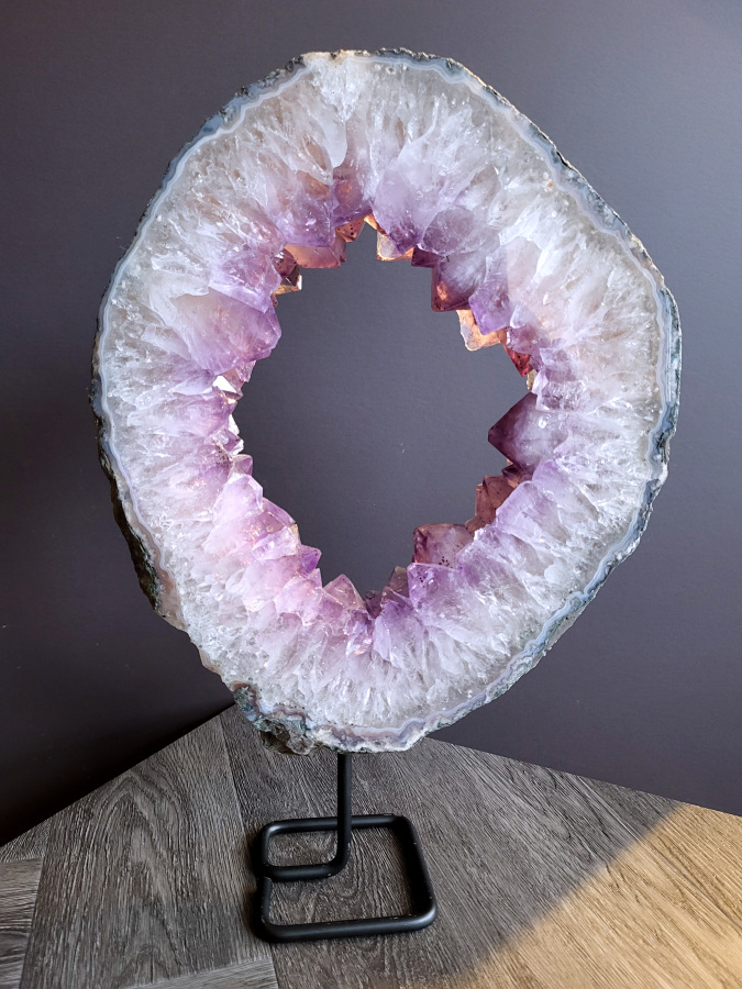 <strong>Amethist, Amethist Portaal, 5,7 kg, 44cm hoog, 257,- euro, nr. 2</strong>

<strong>Amethist is een paarse variëteit van kwarts, bekend om zijn kalmerende en spirituele eigenschappen.</strong> De kleur varieert van licht lila tot diep violet en wordt veroorzaakt door sporen van ijzer en andere elementen. Amethist wordt al eeuwenlang gewaardeerd, zowel vanwege zijn esthetische schoonheid als zijn vermeende genezende en beschermende krachten. 
<strong>Amethist is een kwartskristal, vaak te vinden in geodes (holtes in gesteente) of als afzonderlijke kristallen. 
De kleur varieert van lichtpaars tot diep violet, soms met roze of blauwe tinten. </strong>
De kleurintensiteit kan variëren, waarbij donkerdere amethisten vaak als kwalitatief worden beschouwd. 
Soms vertoont amethist dichroïsme, waarbij je verschillende kleuren kunt zien wanneer je de steen in het licht draait. 

<strong>Vindplaatsen:</strong>
Amethist wordt gevonden in verschillende delen van de wereld, waaronder Brazilië, Uruguay, Zambia, Madagaskar, Rusland en Canada.
Het wordt vaak gevonden in bergachtige gebieden. 

Gebruik:
<strong>Amethist wordt gebruikt in sieraden, decoratieve objecten en als helende steen. </strong>
Het wordt vaak gedragen als hanger, ring of armband, of geplaatst in ruimtes om de energie te zuiveren. 
<strong>Amethist wordt ook gebruikt in meditatie en andere spirituele praktijken. </strong>